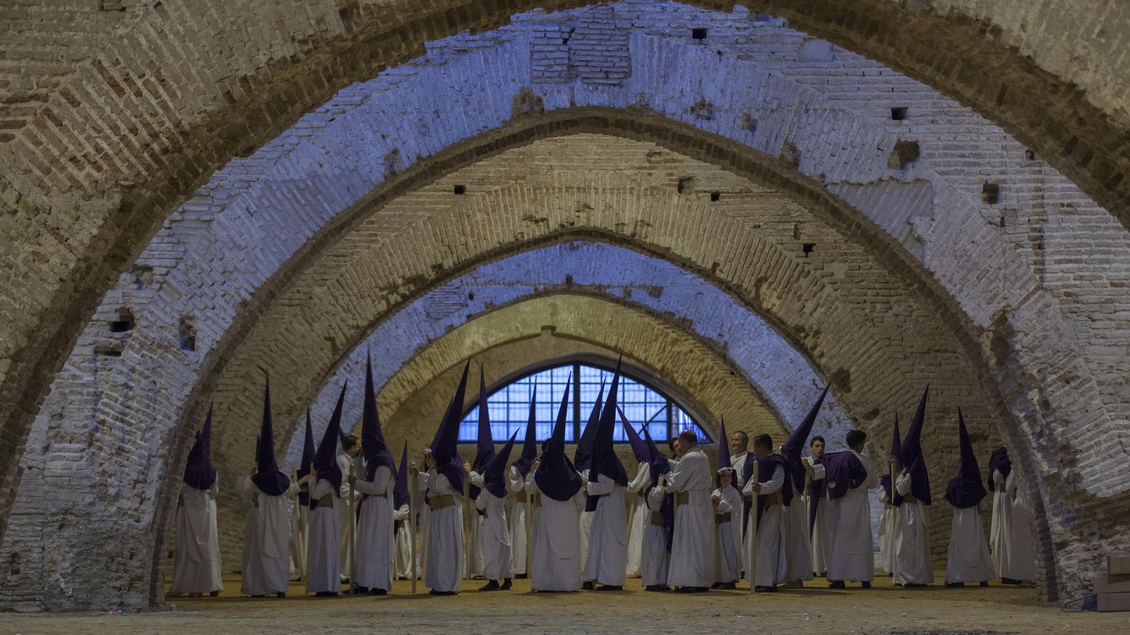 Los nazarenos de la Hermandad de las Aguas formando en el antiguo astillero.