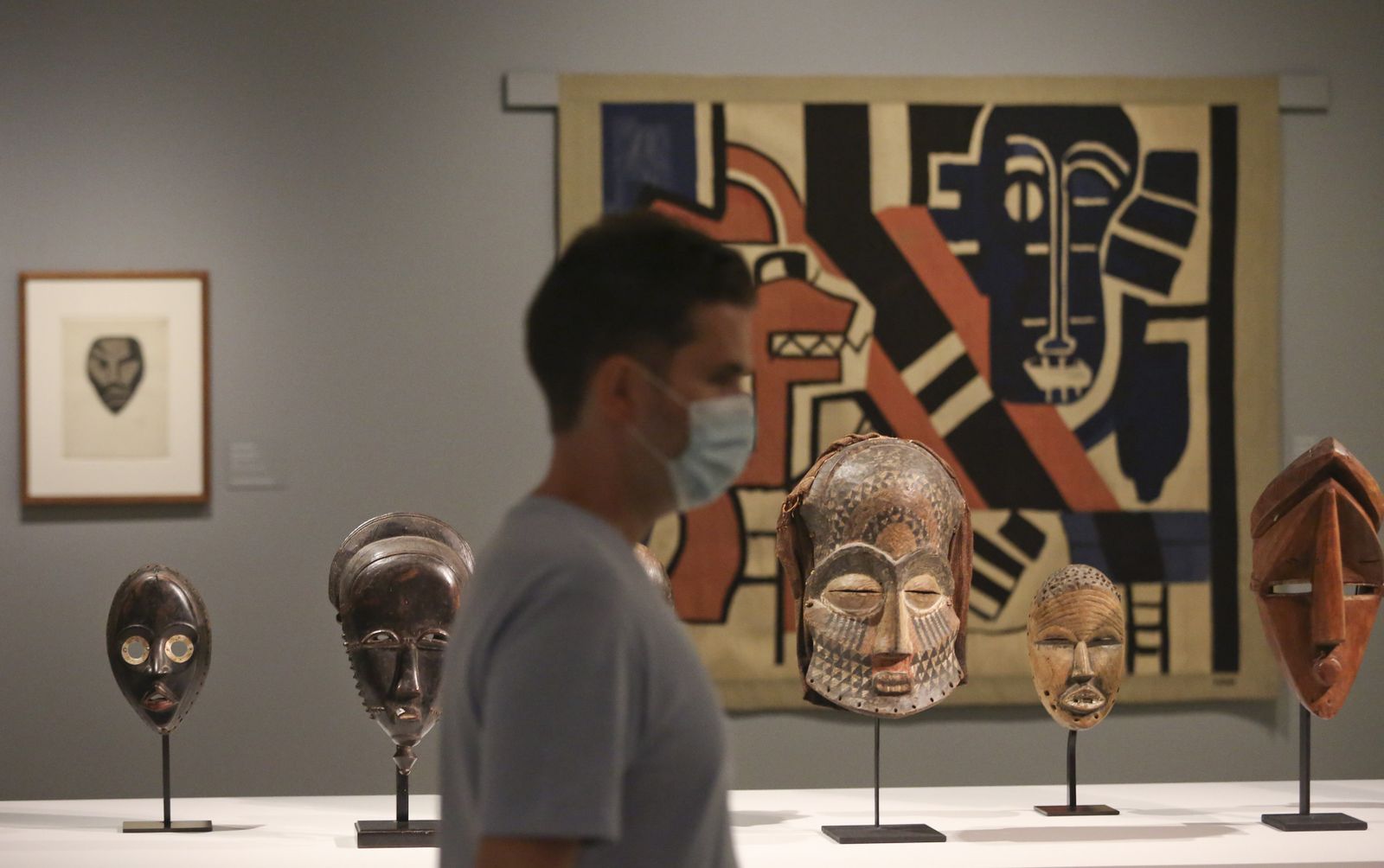 Máscaras étnicas y, al fondo, 'La máscara negra' (1930-1936) de Fernand Léger, en la nueva exposición del Museo Carmen Thyssen Málaga.