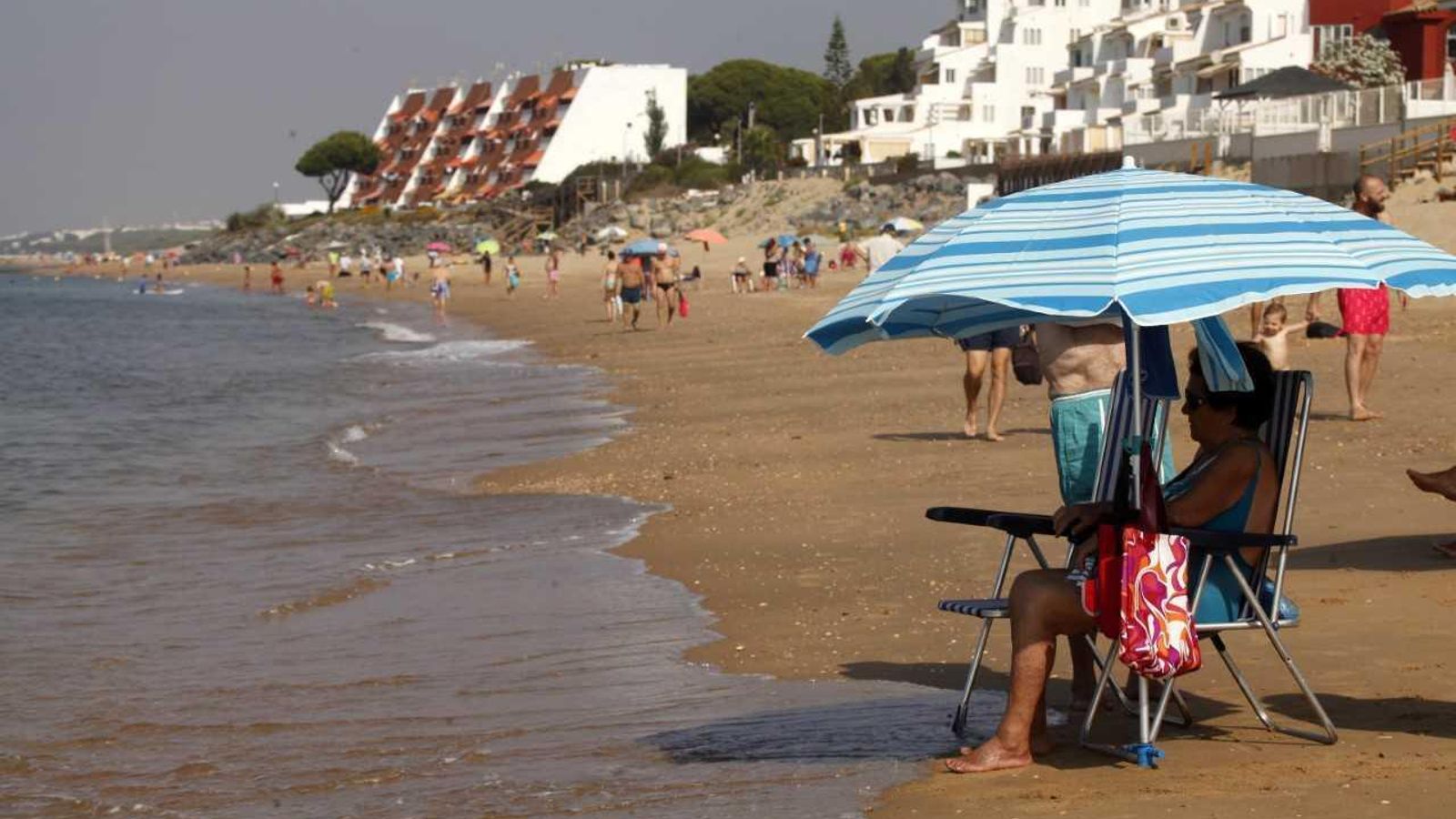 Una mujer disfruta en la orilla de las vistas en la playa de El Portil.