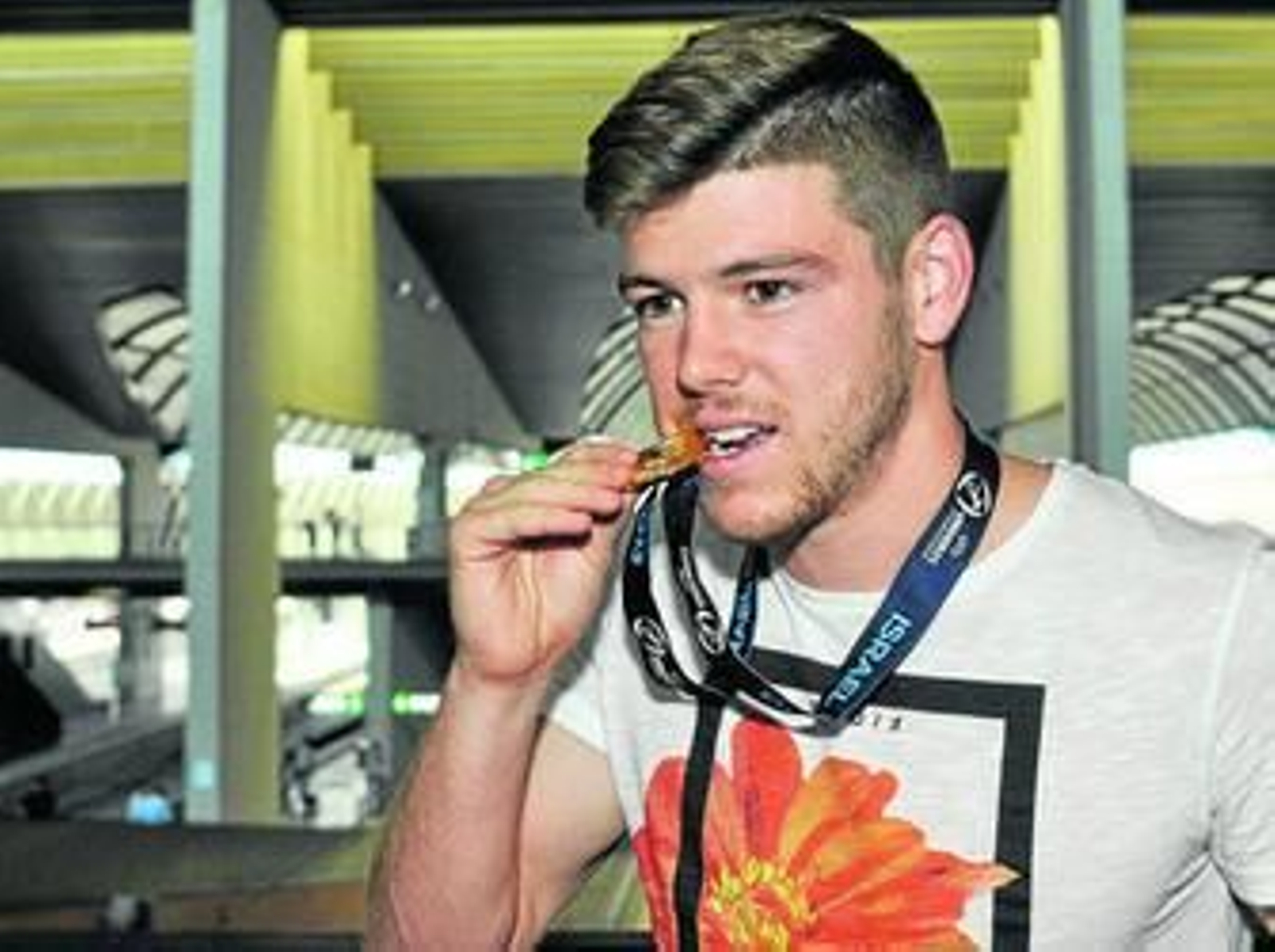 Alberto Moreno muerde su medalla de oro tras bajar del AVE.