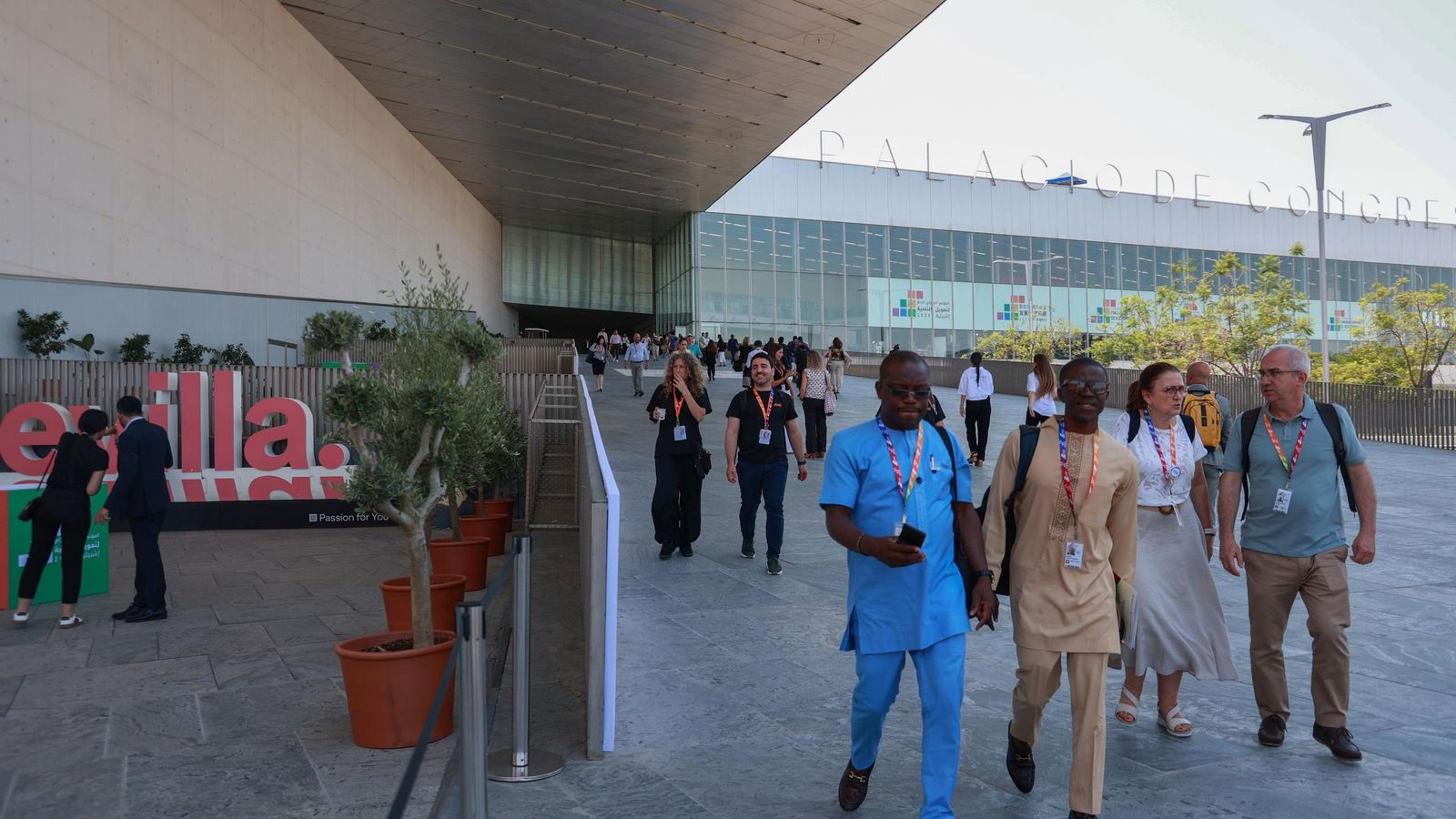 Varios asistentes y trabajadores bajan por la rampa principal del Palacio de Congresos. Varios asistentes y trabajadores bajan por la rampa principal del Palacio de Congresos.