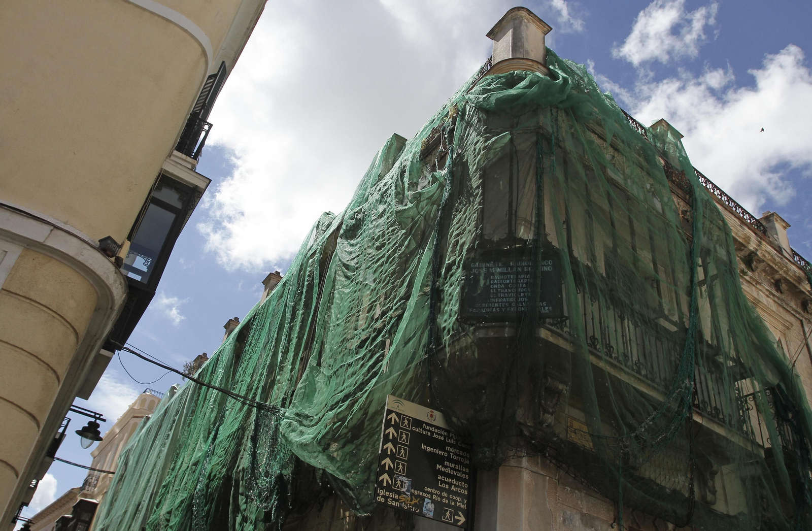 La fachada de la Casa Millán, en la esquina de la Plaza Alta, con la red verde de seguridad.