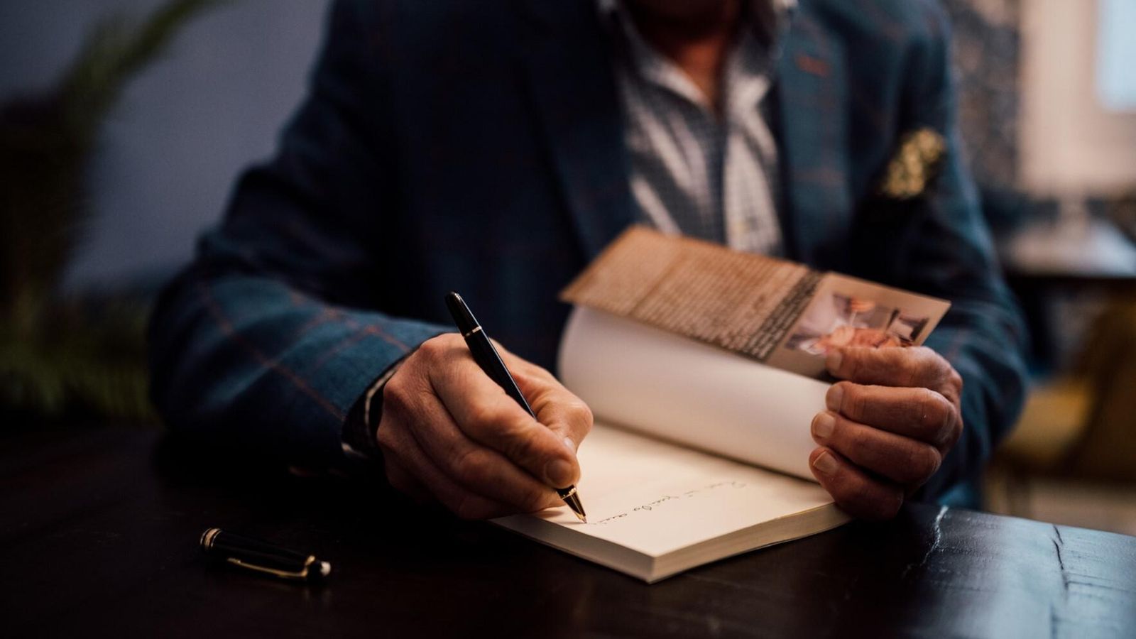 Miguel Ángel Velasco firma un ejemplar de una de sus novelas.