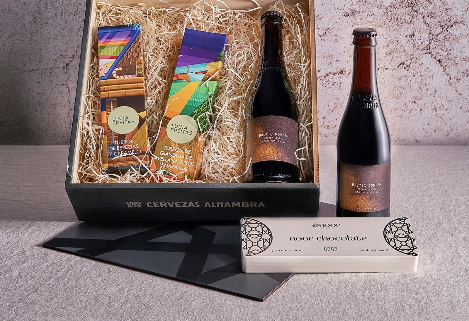 Este lote gourmet está compuesto por dos variedades de turrones artesanos,  chocolates con forman de almena y un par de cervezas  Alhambra Baltic Porter