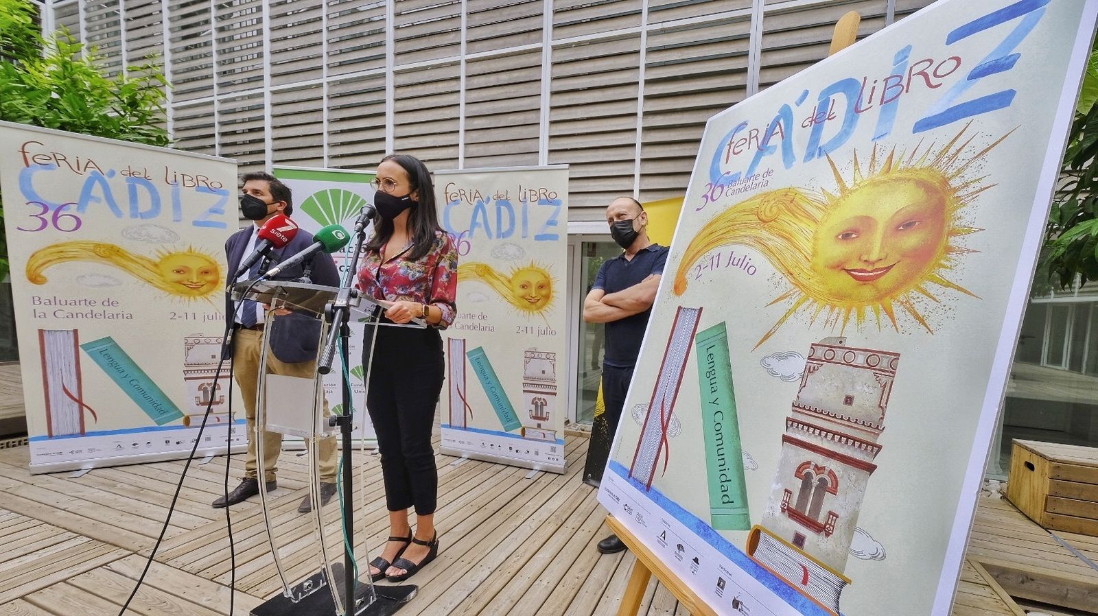 Lola Cazalilla, Rafael Muñoz y Juan José Sandoval presentan la Feria del Libro ante el cartel original de Ana Juan.