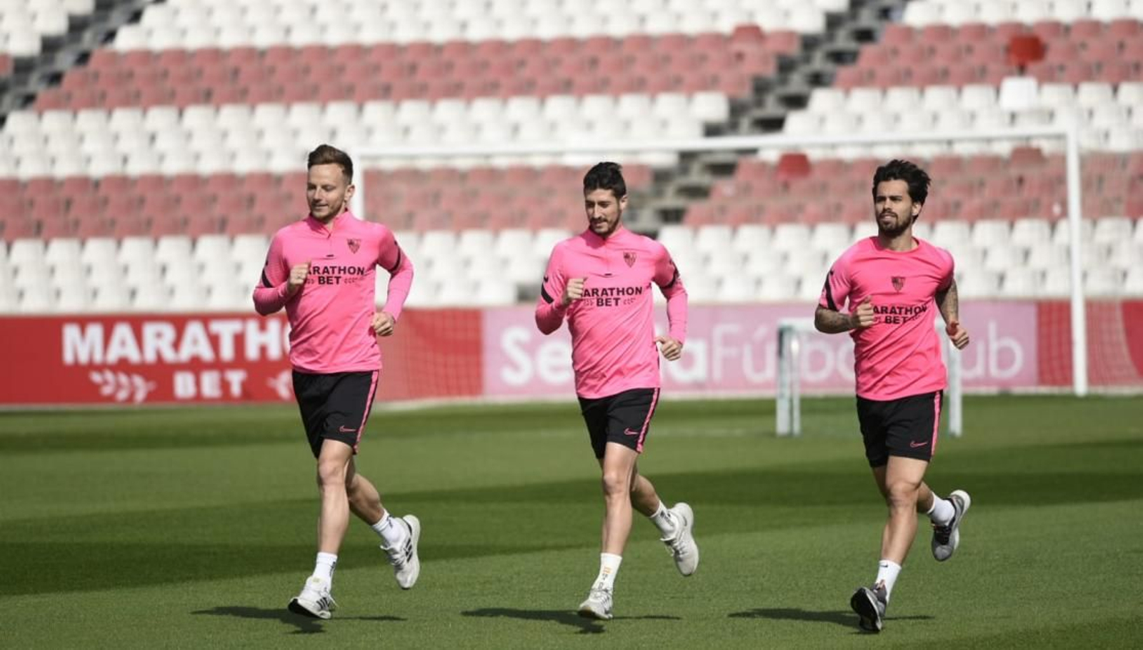 Rakitic, Escudero sonríen mientras realizan carrera continua con Suso.