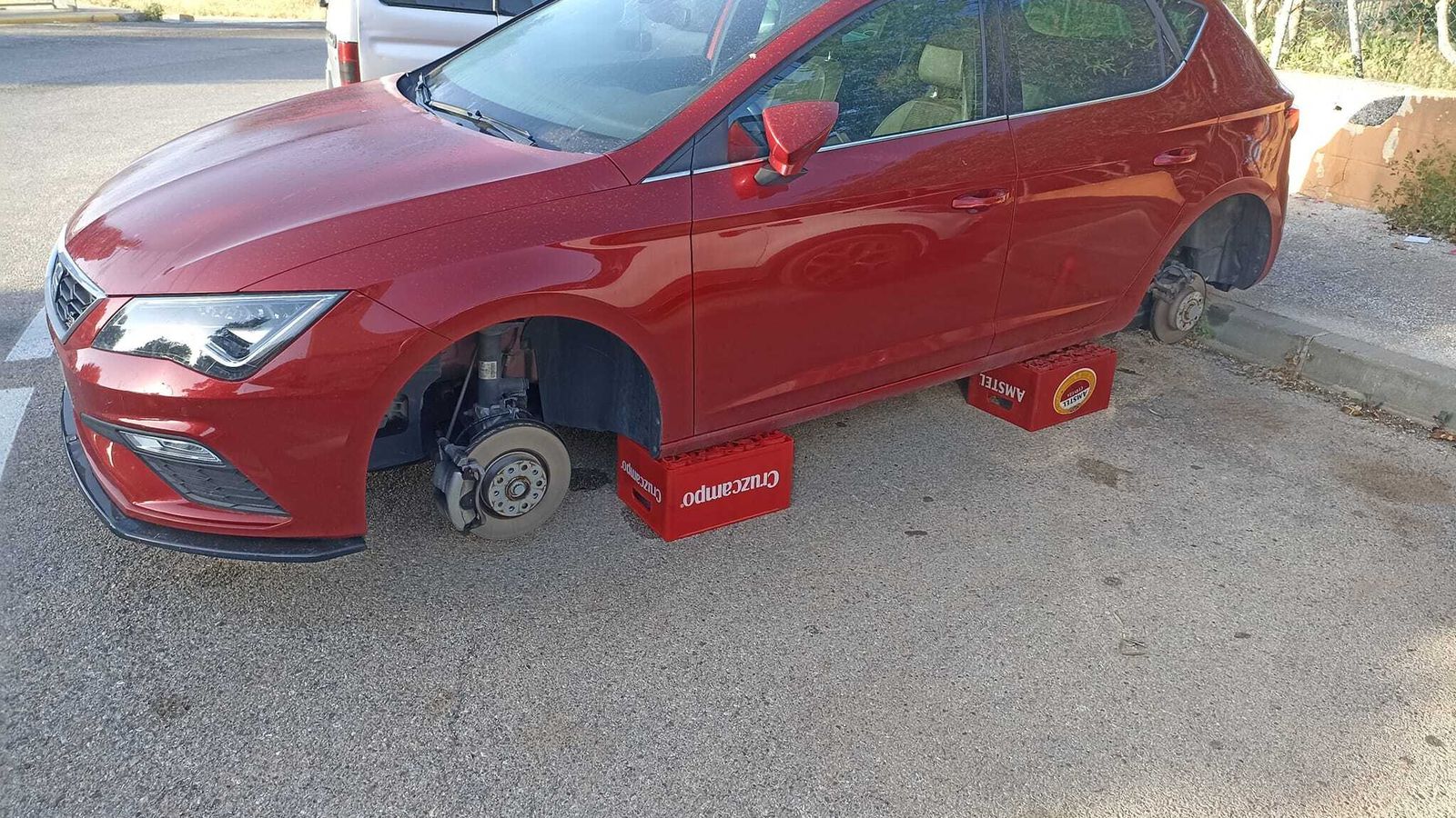 El Seat León sin ruedas, apoyado sobre cajas de cerveza.