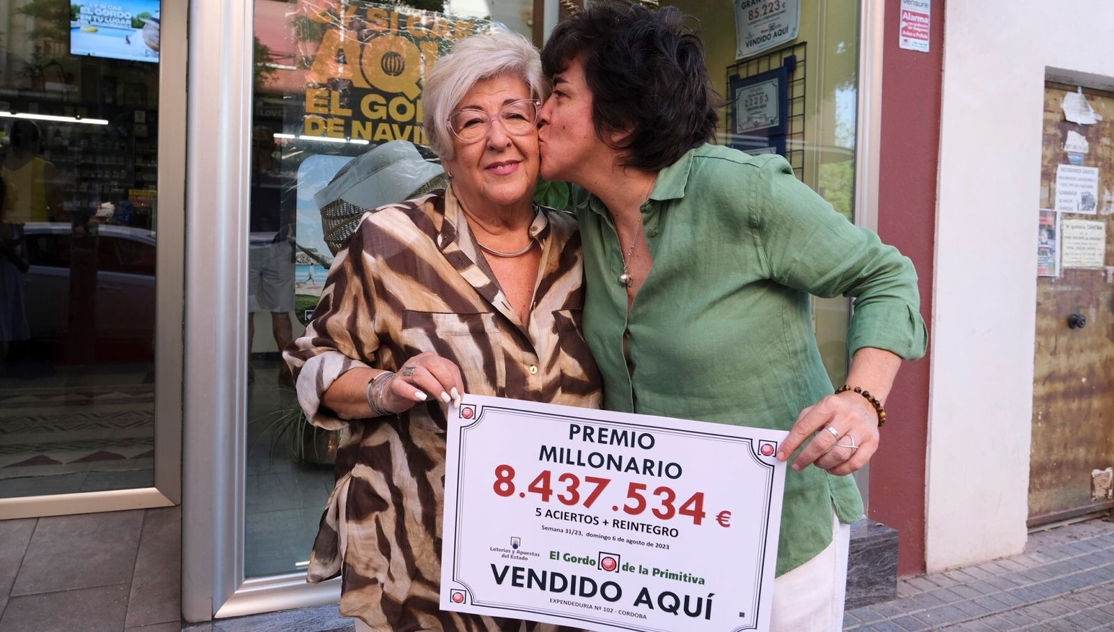 Marisa Rodríguez y su hija África Úbeda, con el cartel del primer premio del Gordo de la Primitiva.
