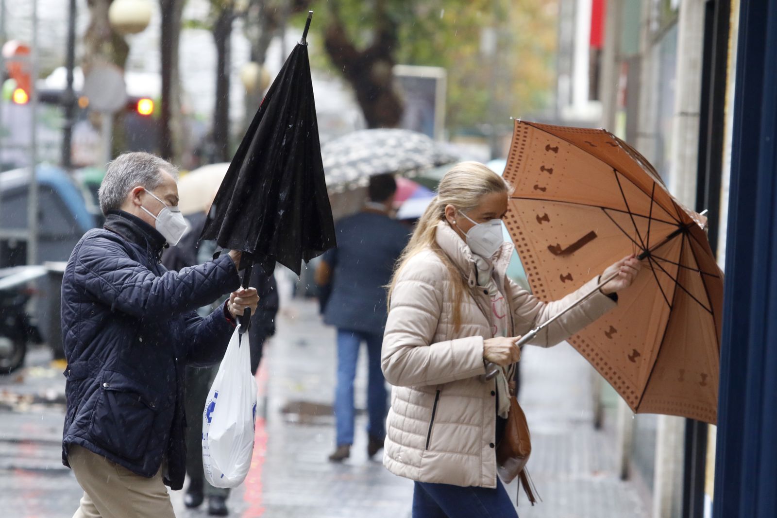 Una pareja se resguarda de la lluvia en la capital.