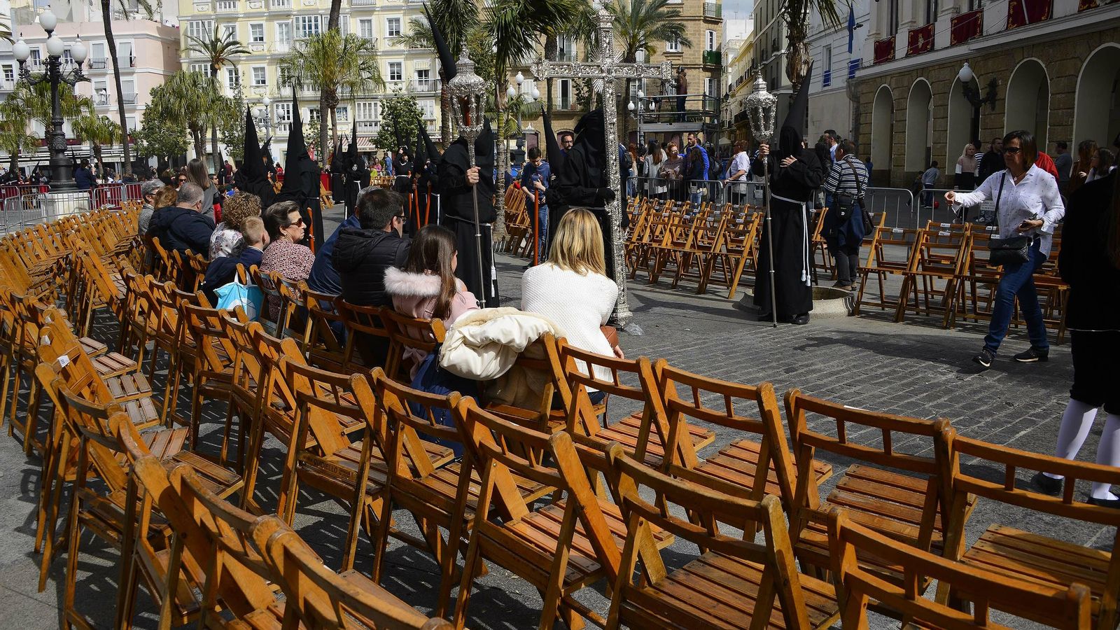 Sillas vacías durante el paso de la cofradía del Santo Entierro