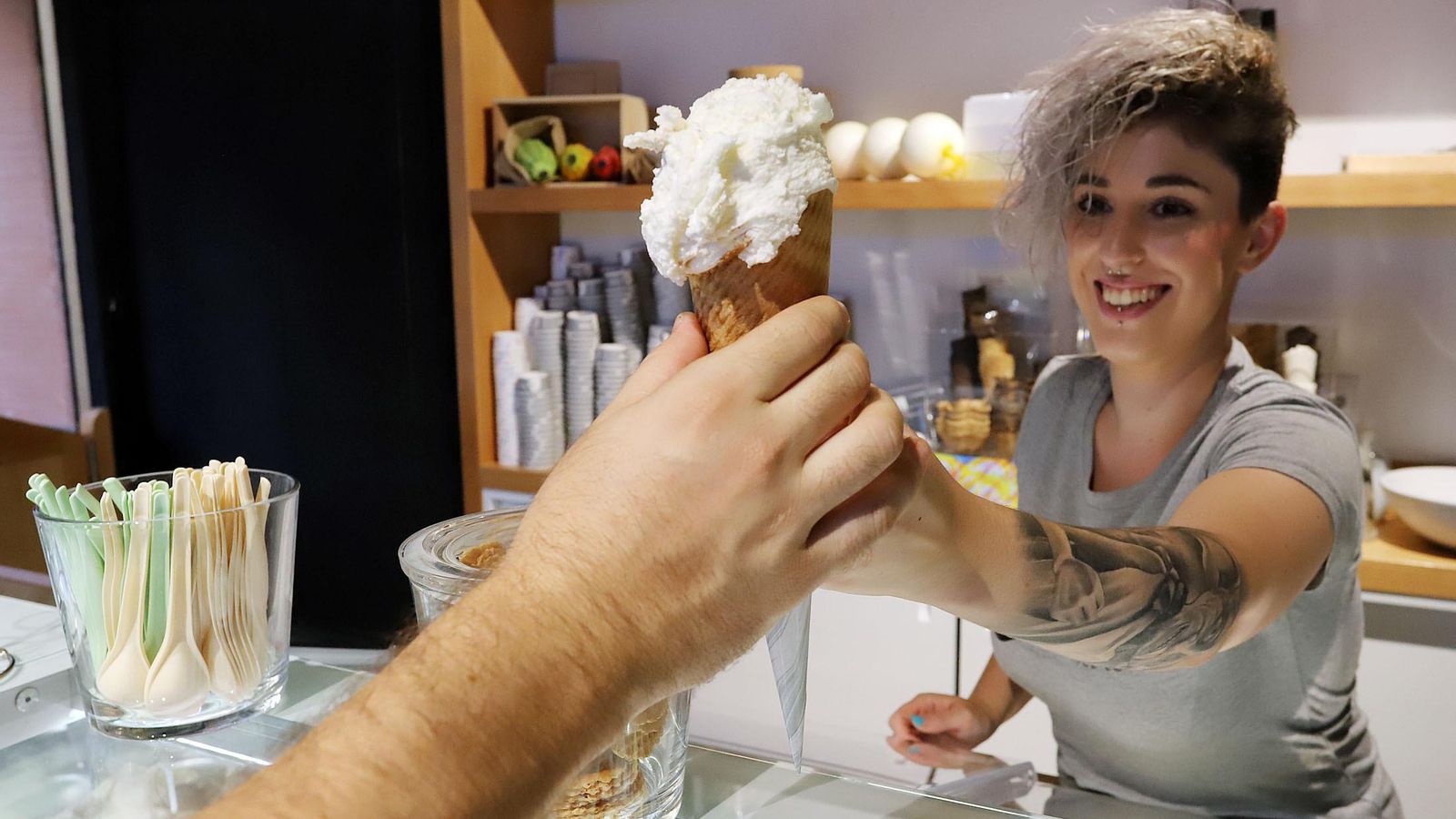 Una chica entrega a un cliente un helado de Nuuk.