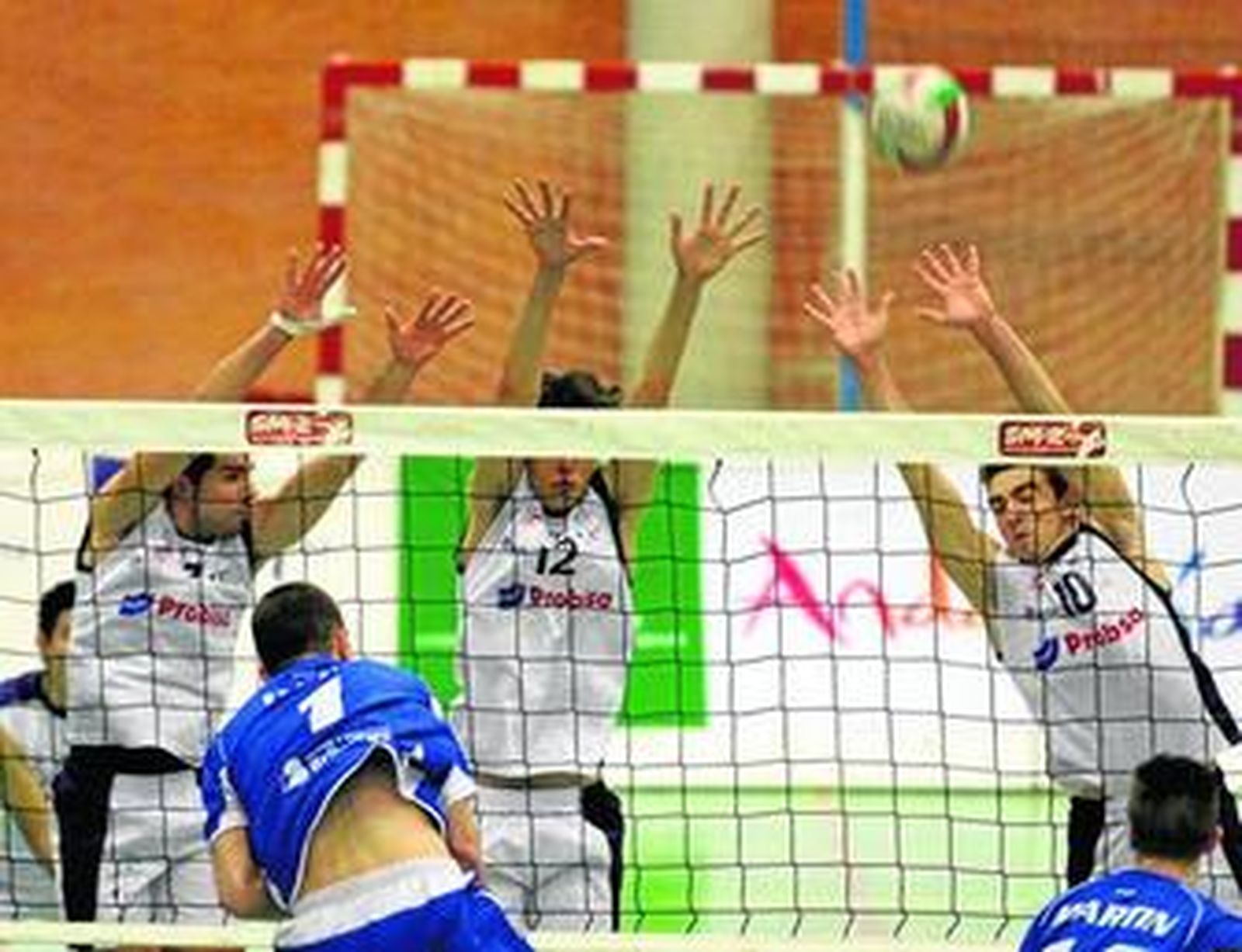 Tres jugadores del UMA Probisa Pizarra intentan defender un ataque del Voley Guada, en 2009.