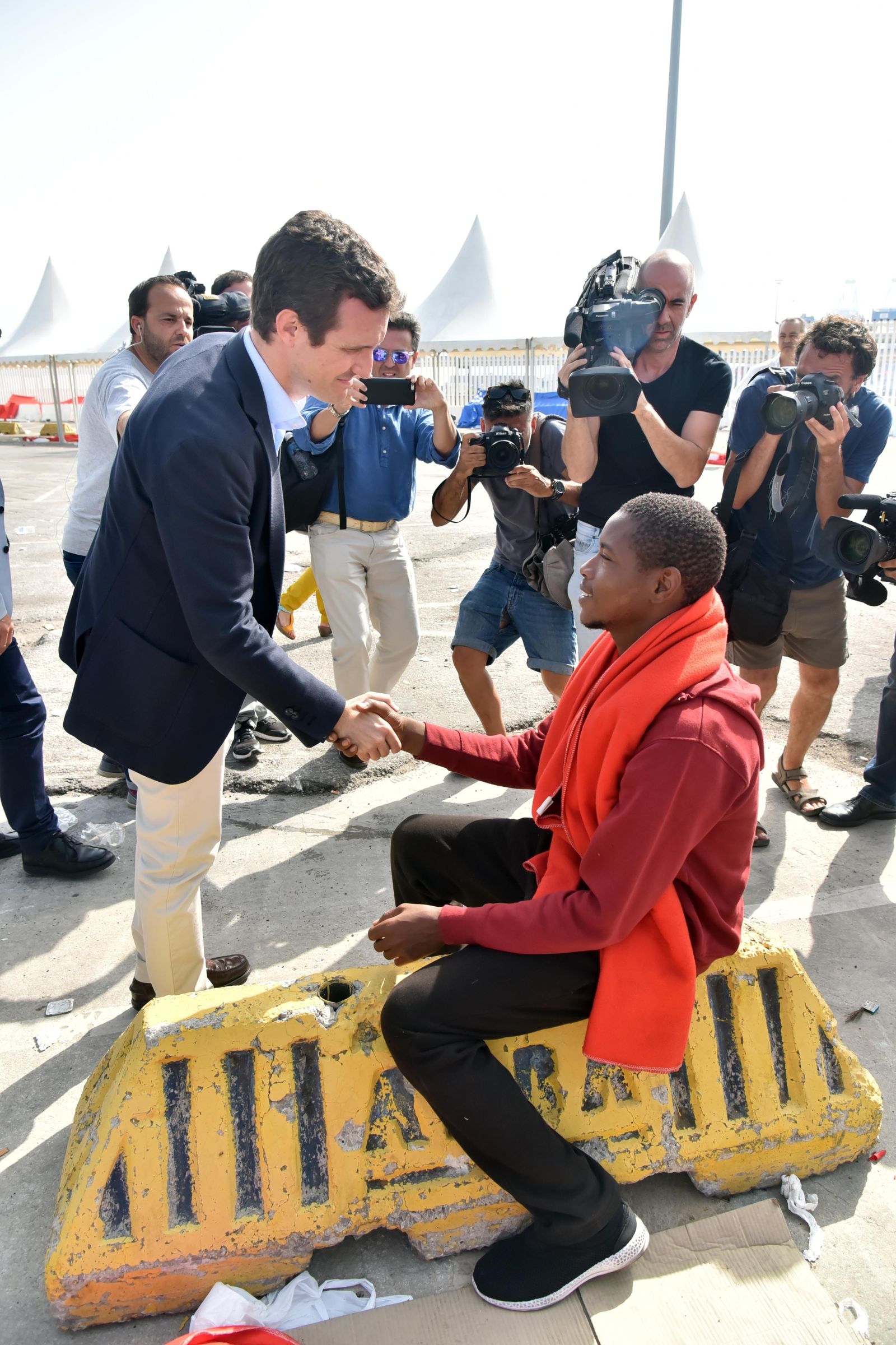 El presidente del PP, Pablo Casado, saluda a un migrante en el Puerto de Algeciras, ayer por la mañana.