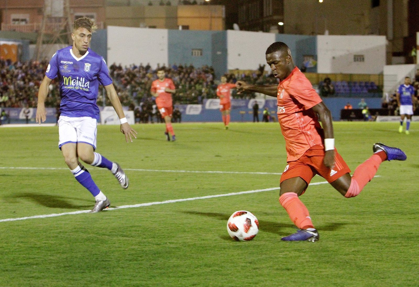 Vinícius centra ante un jugador del Melilla.