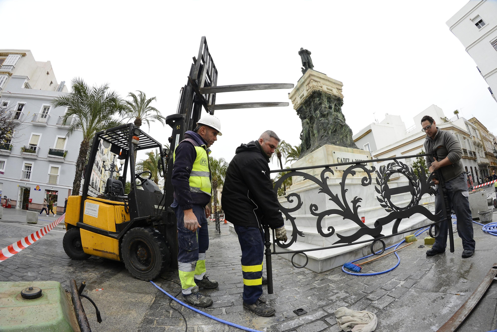 Operarios municipales colocan la valla alrededor del monumento a Moret.