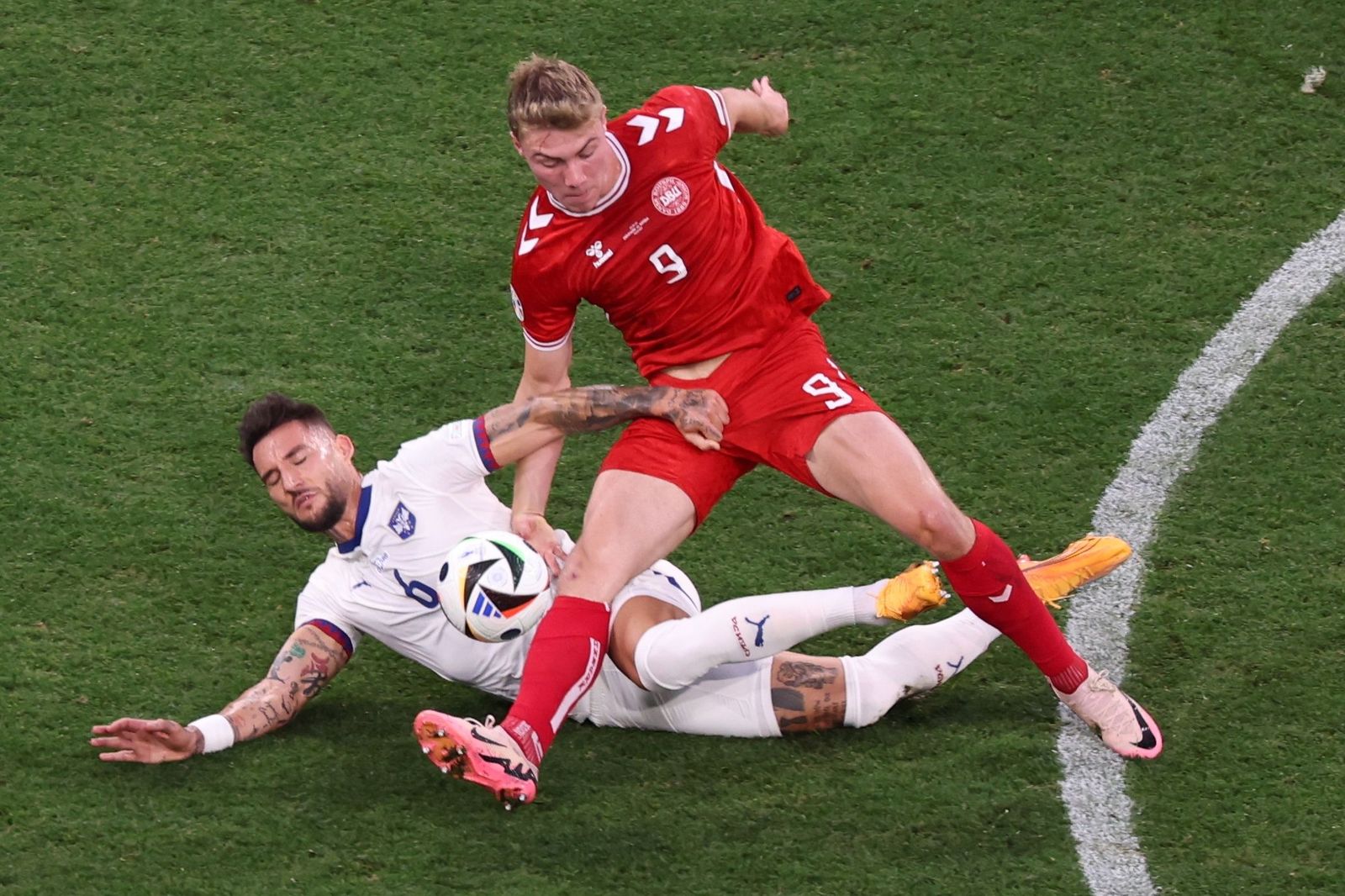 Nemanja Gudelj en un acción por el suelo junto a Rasmus Hojlund.