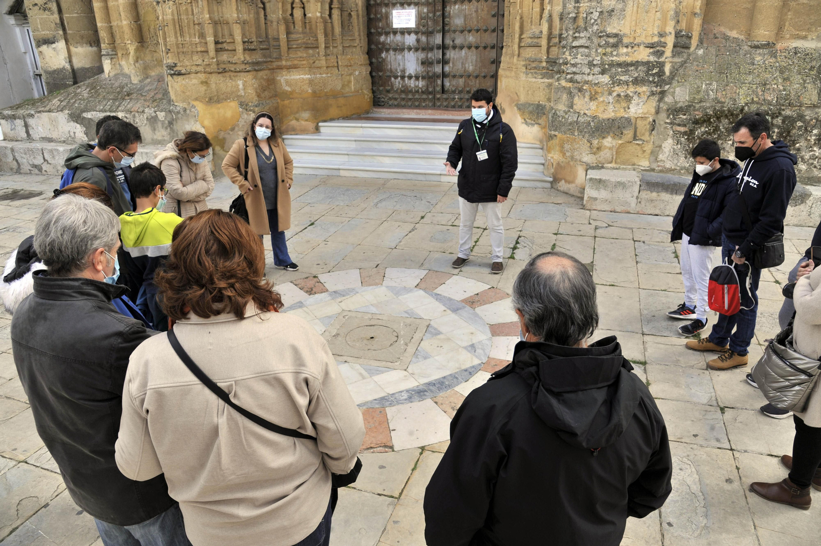 Un grupo de turistas atiende las explicaciones de un guía en Arcos.