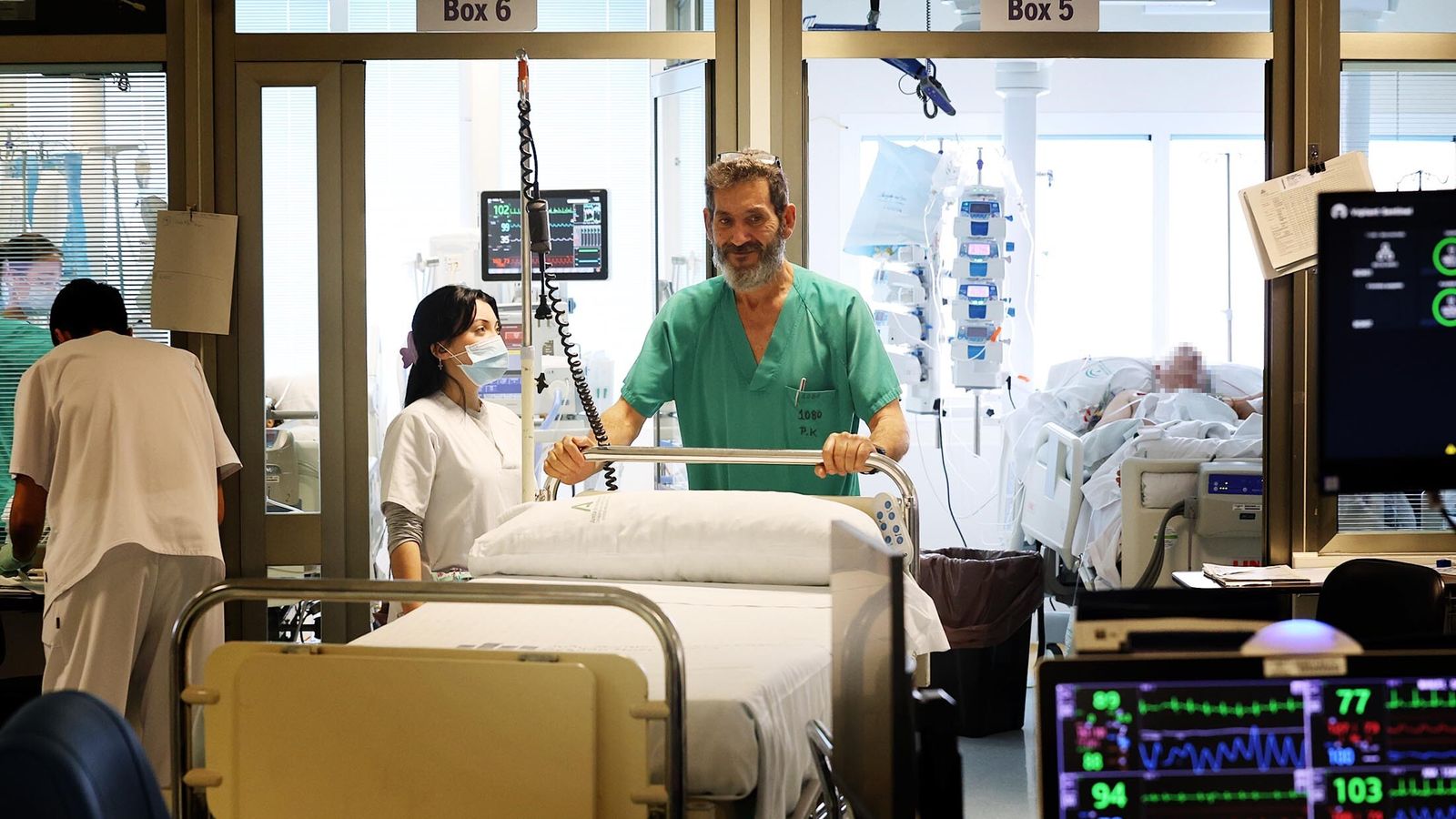 Un profesional sanitario transporta una camilla en la UCI.