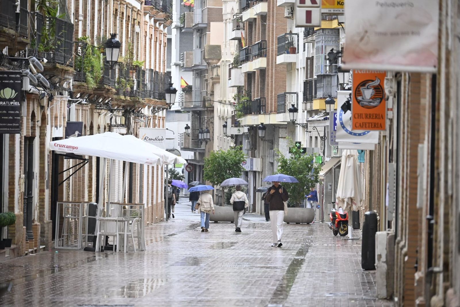 Onubenses durante la tarde de lluvia de este martes.