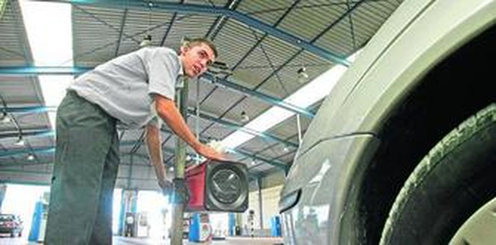 Un técnico hace una prueba con las luces de un turismo.