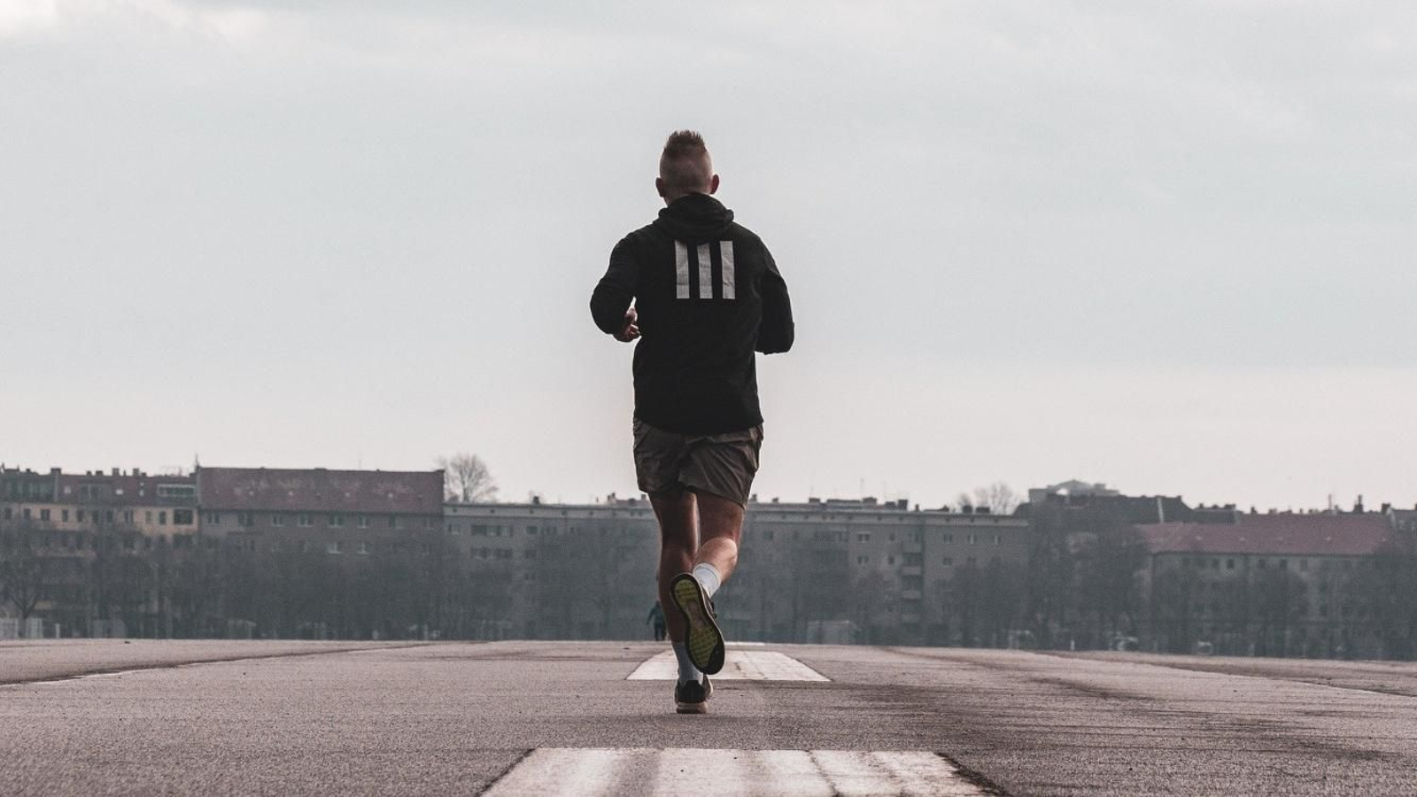 Un hombre avanza corriendo mientras practica deporte.