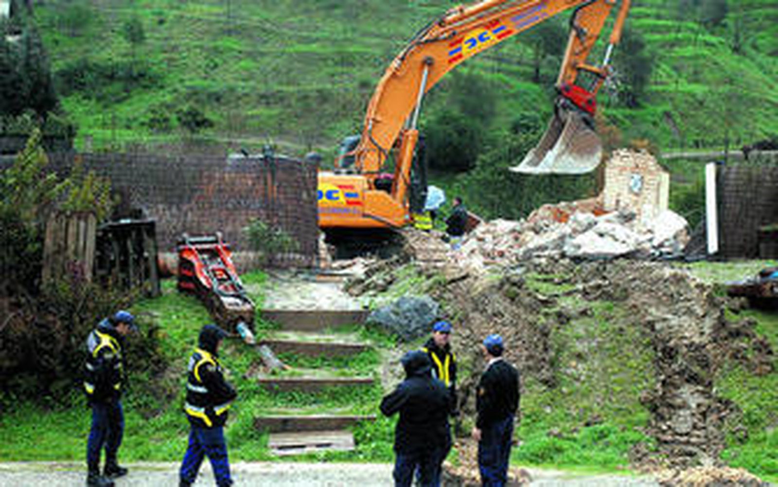 Operarios supervisan el derribo de la casa ilegal iniciado ayer por sorpresa.