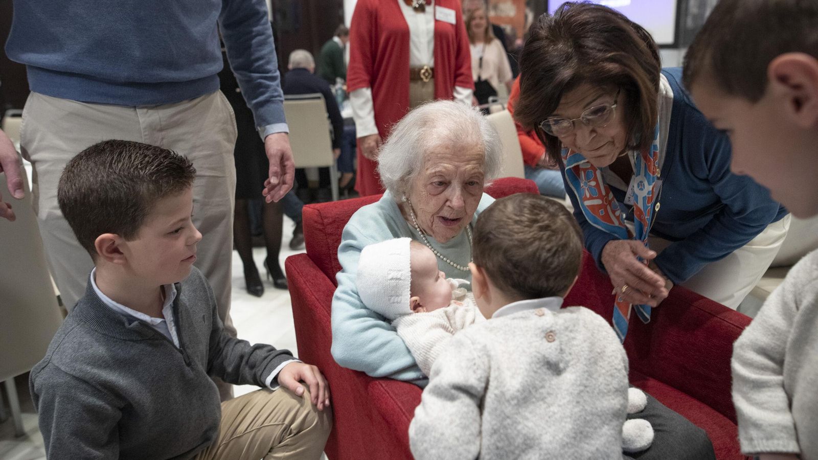Juanita Entrala Fernández, con cien años, coge en sus brazos a Carmen Jerez Cabello, de tan solo tres meses.