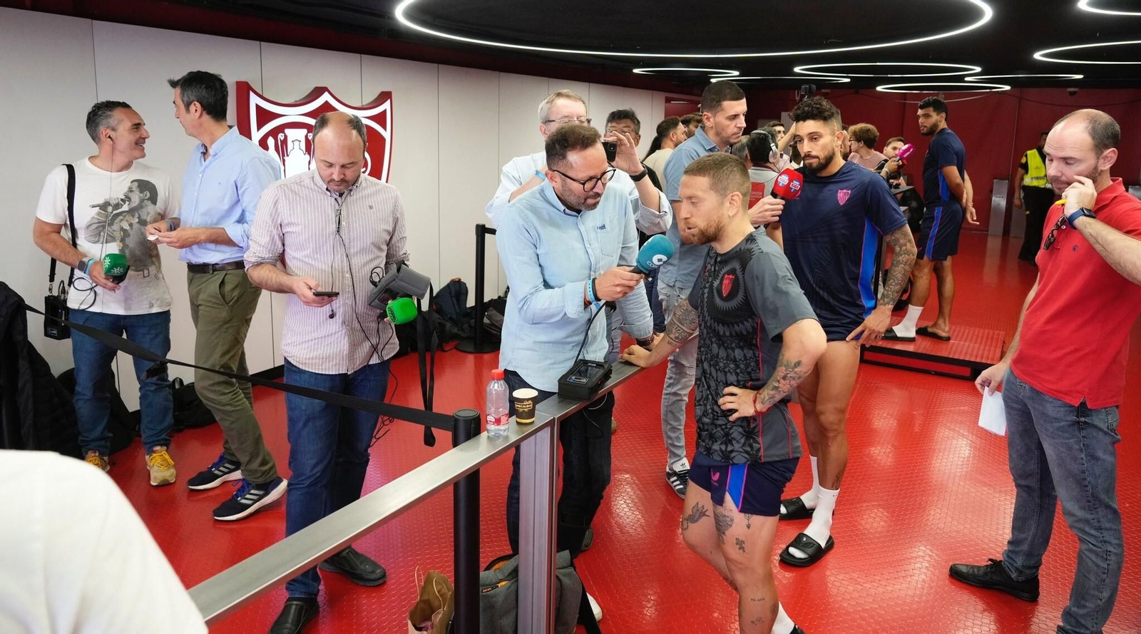 Papu Gómez, Alex Telles y Rekik atiende a los diferentes medios en el pasillo junto a los vestuarios.