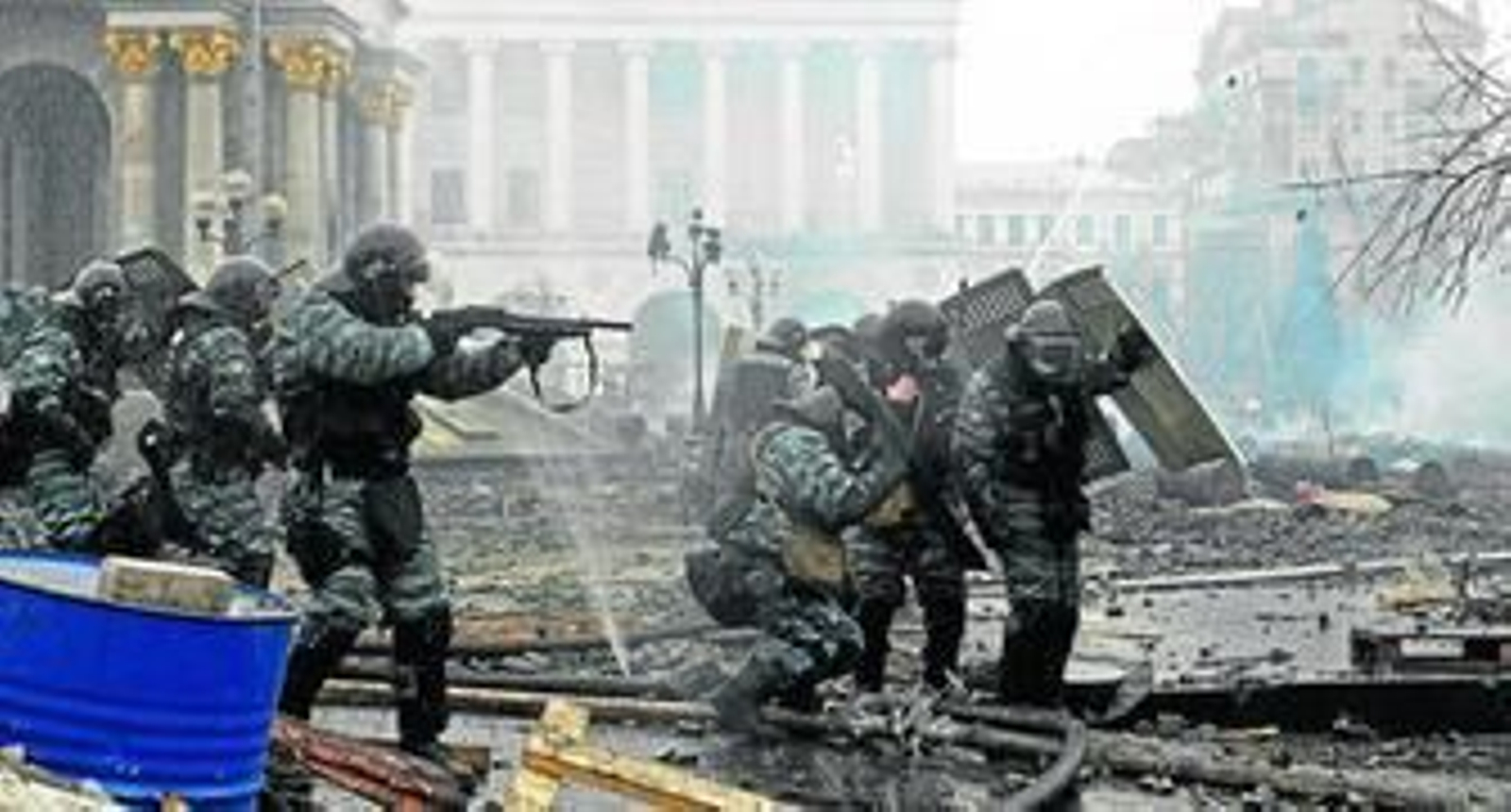 Policías antidisturbios se ponen a cubierto durante los enfrentamientos en la Plaza de la Independencia de Kiev.