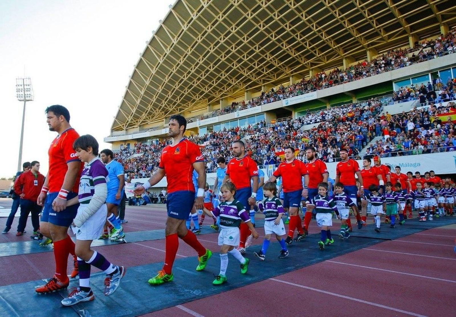 Jugadores de España y Uruguay saltan al césped del Estadio Ciudad de Málaga.