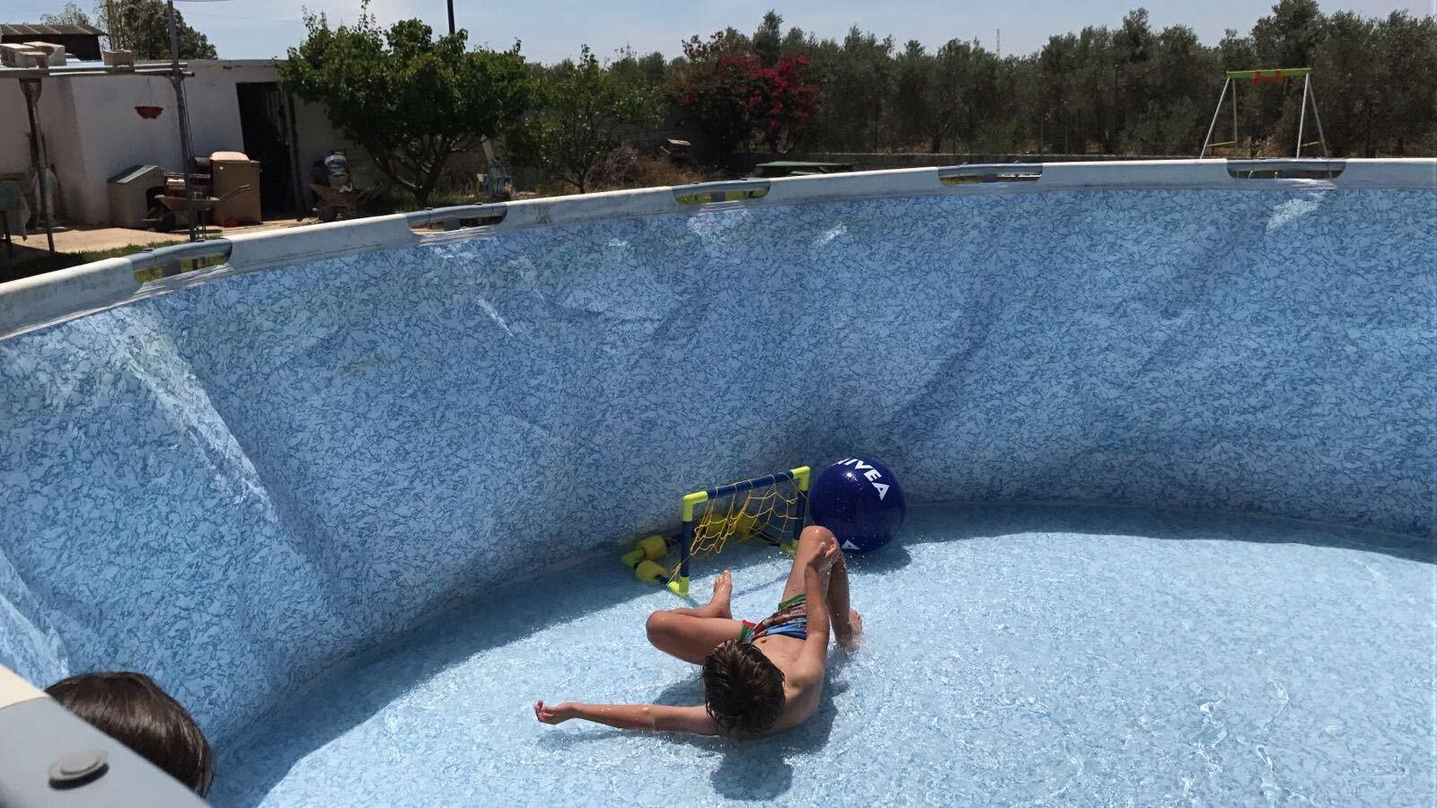 Un pequeño empieza a disfrutar de su nueva piscina mientras se llena