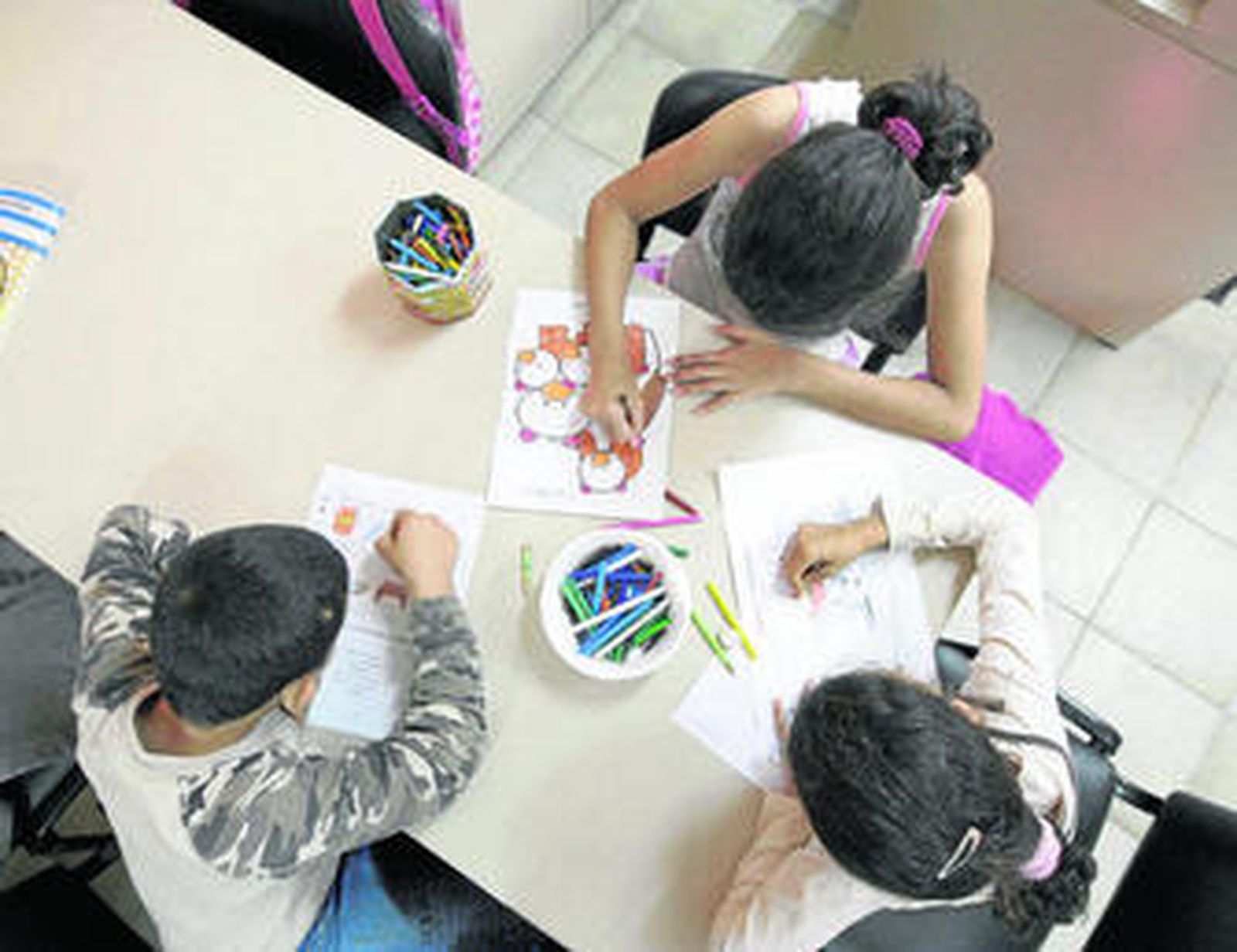 Niños en un colegio de la barriada de El Puche hacen sus tareas en clase.