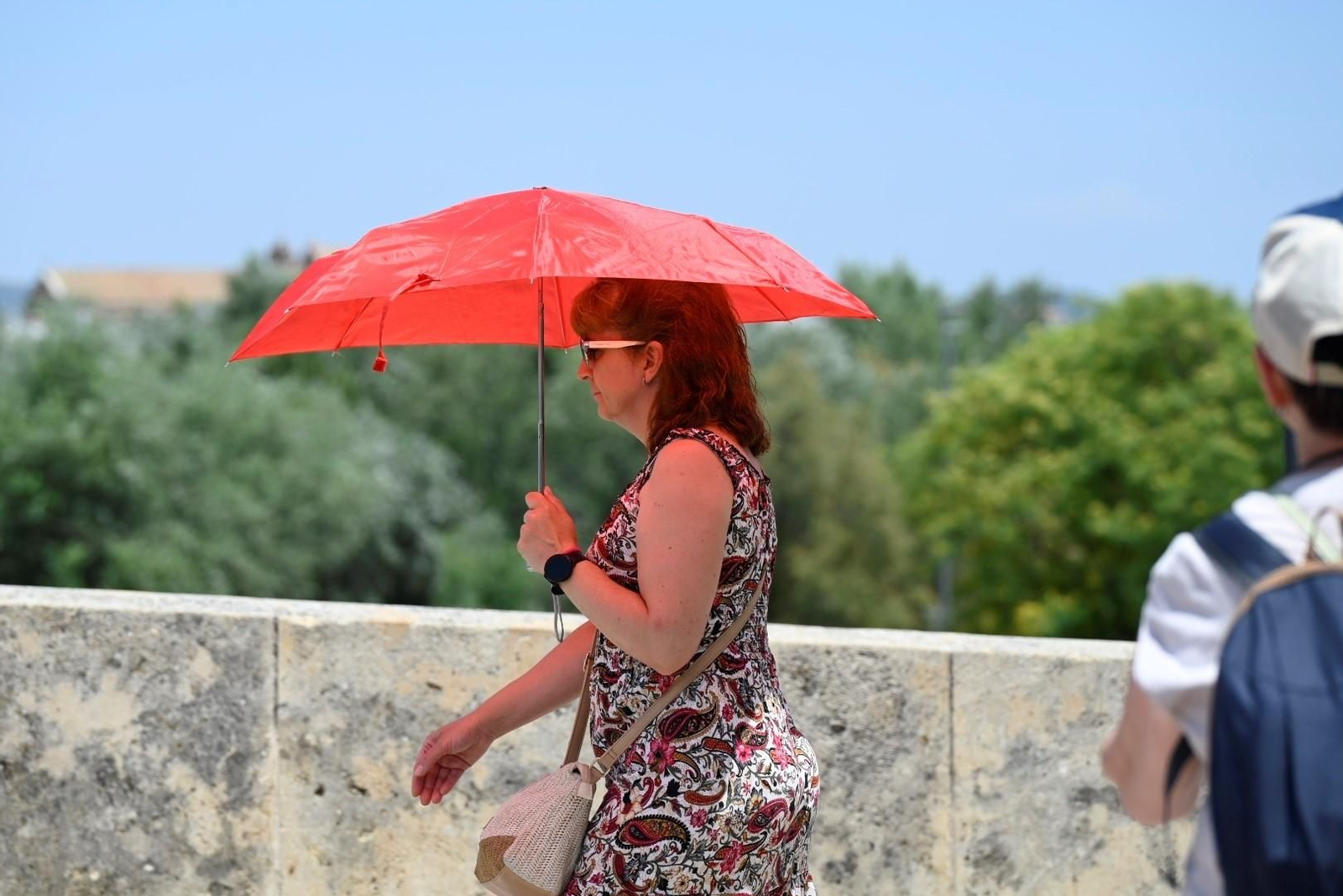 Una mujer se protege del sol en Córdoba con un paraguas.