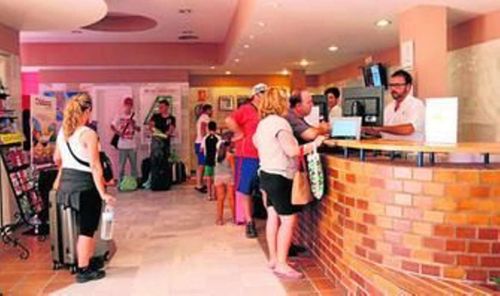 Imagen de archivo de varios turistas en la recepción de un hotel.