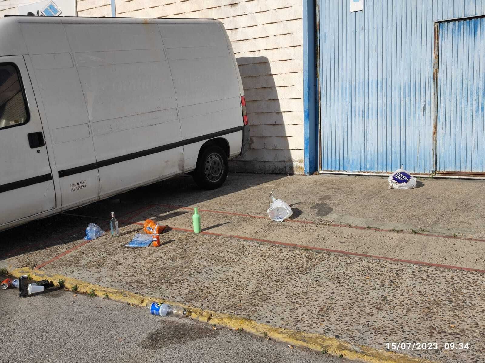 Restos de un botellón en la entrada de una nave en Fadricas.