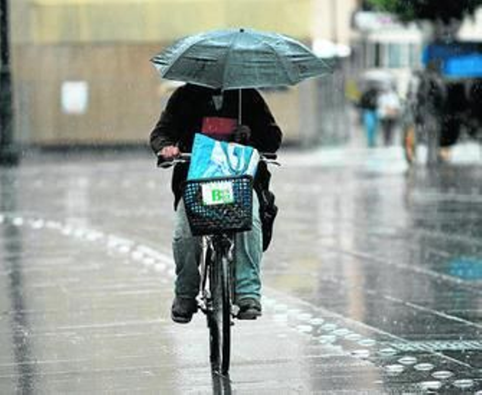 Un ciclista atraviesa la Avenida de la Constitución bajo la lluvia, ayer por la mañana.