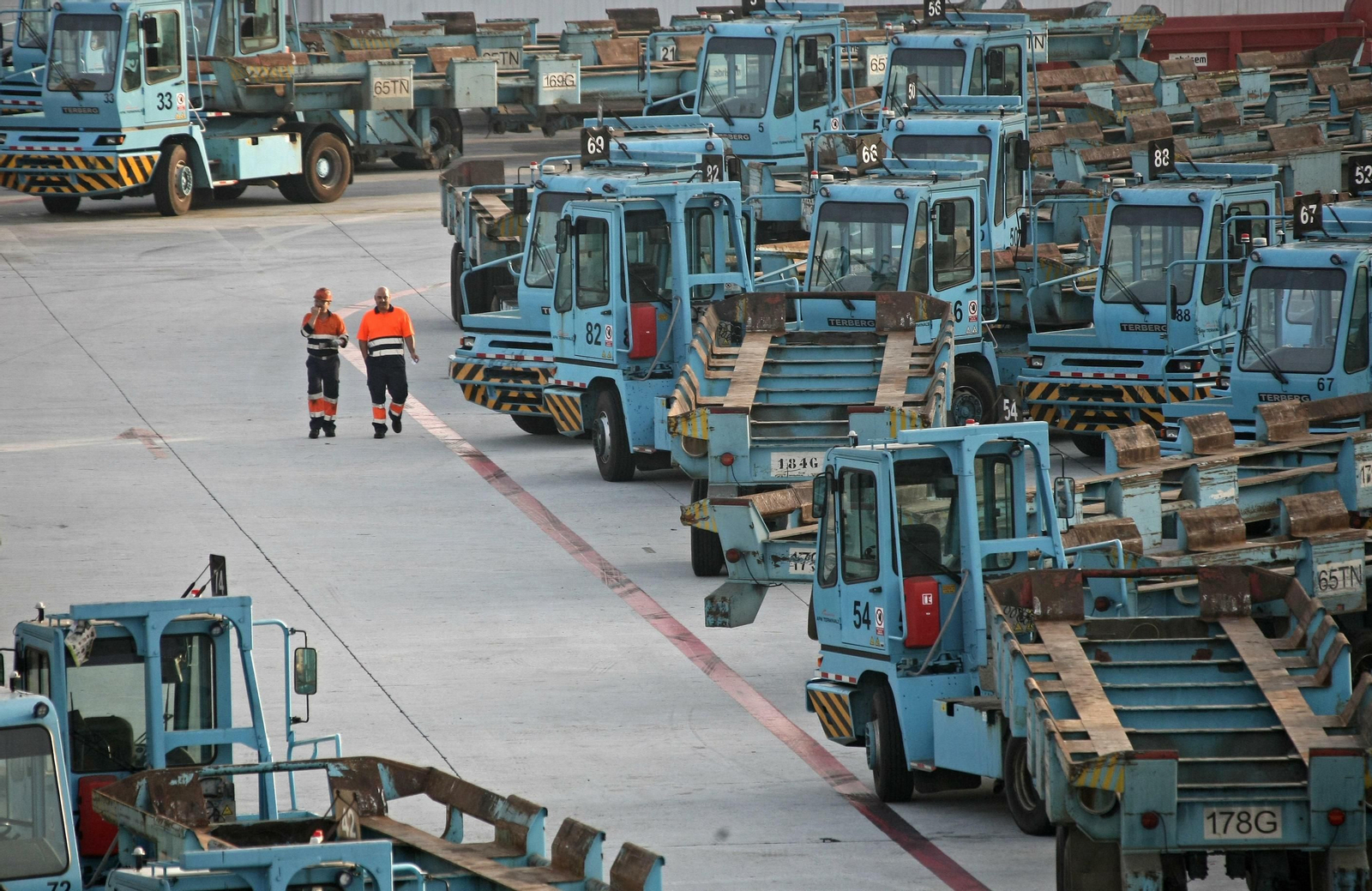 Dos portuarios caminan por el aparcamiento de tractoras de APM Terminals Algeciras.