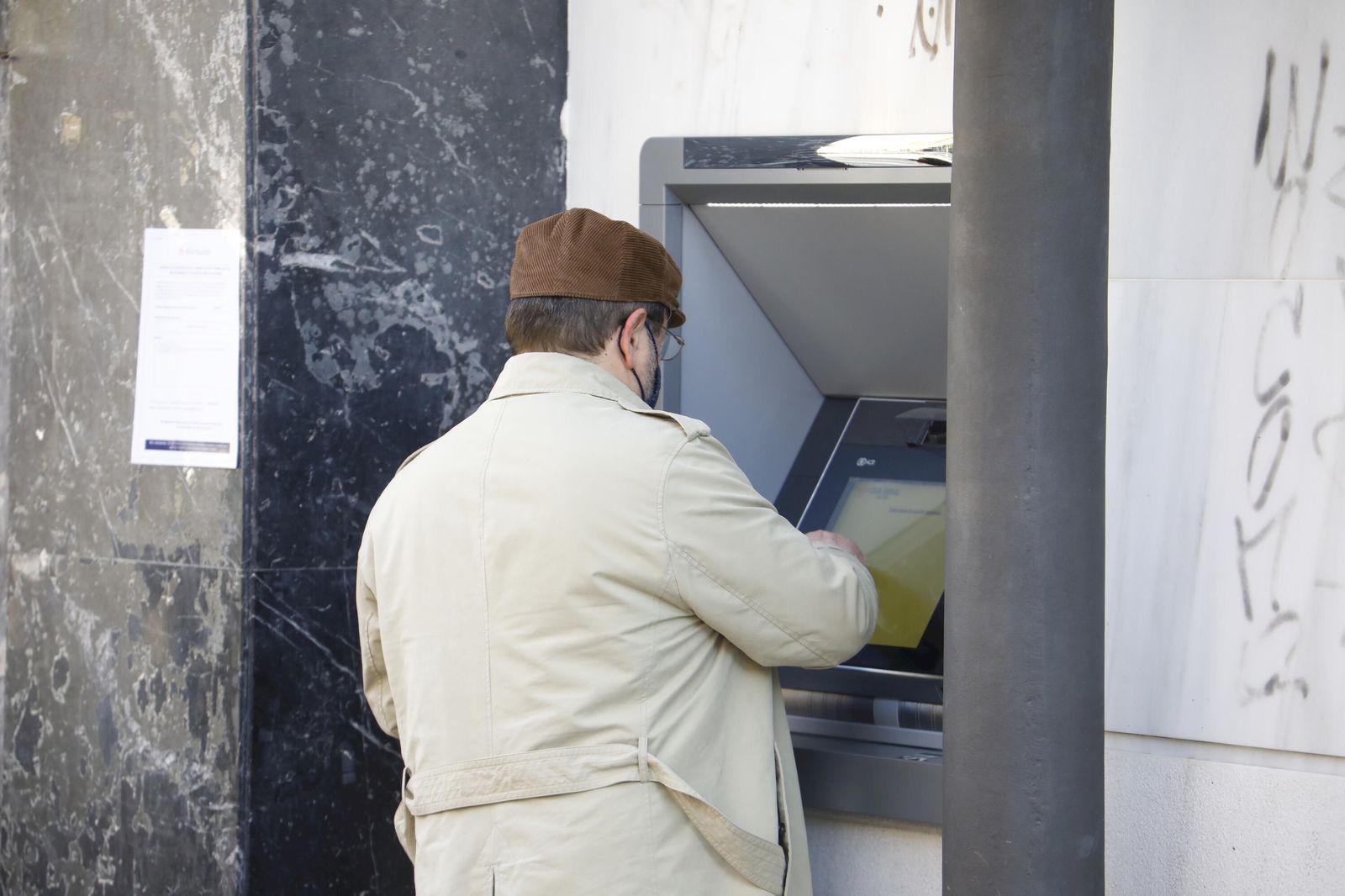 Un hombre saca dinero de un cajero  automático