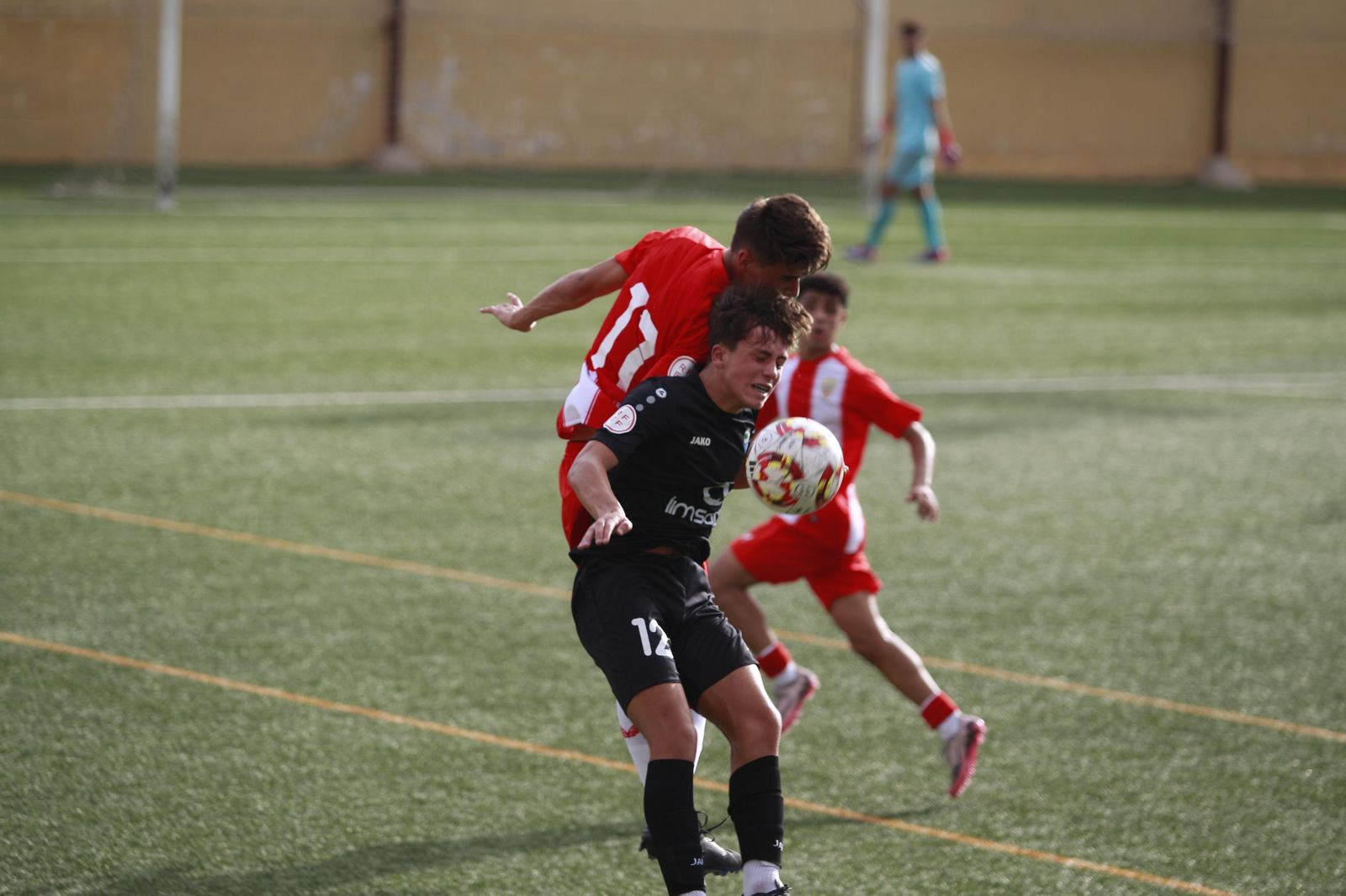 Jugadores de ambos equipos disputan un balón aéreo durante el encuentro de la primera vuelta disputado en el Francisco Pomedio.