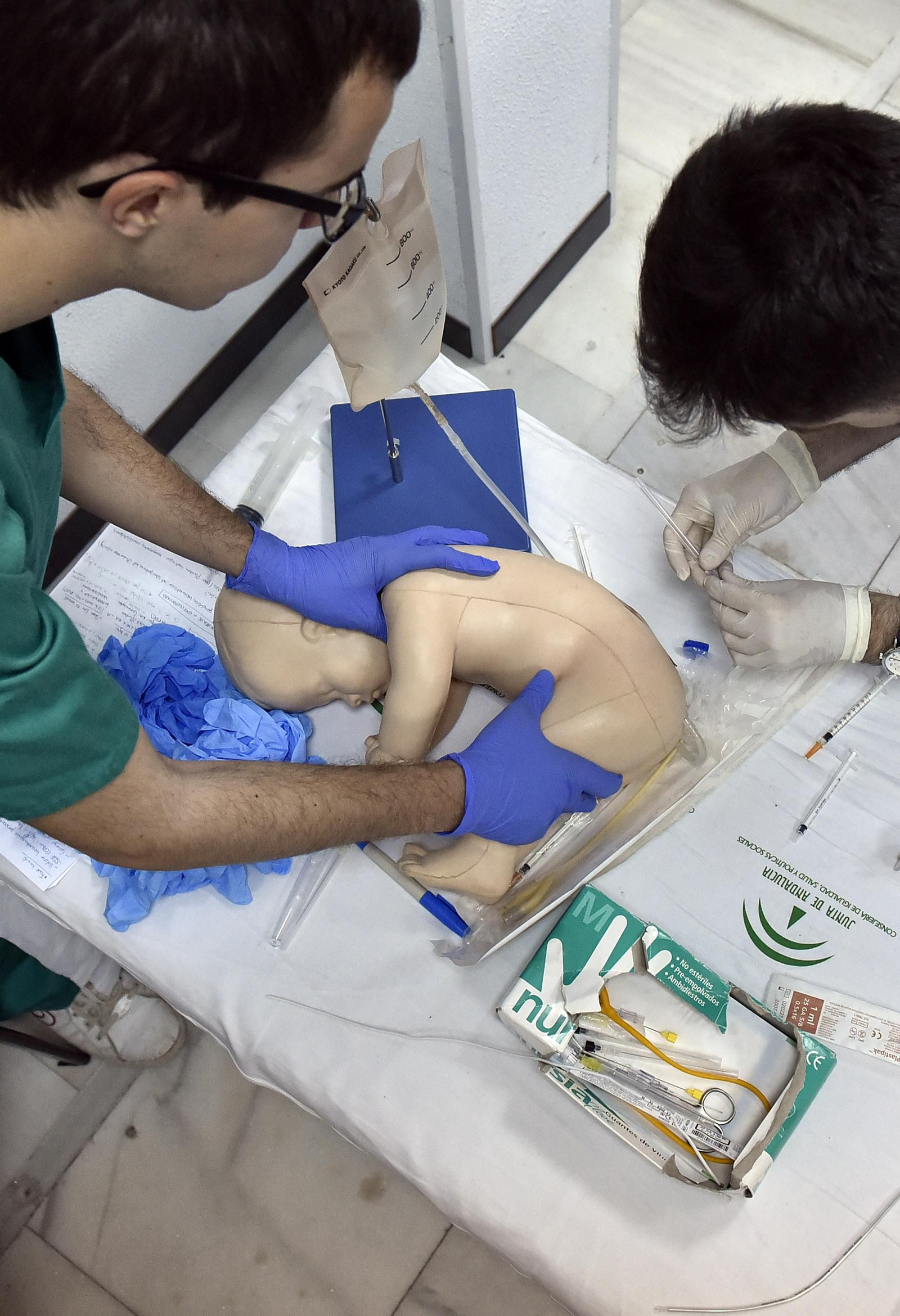Alumnos de Medicina se adiestran para hacer una punción a un bebé.