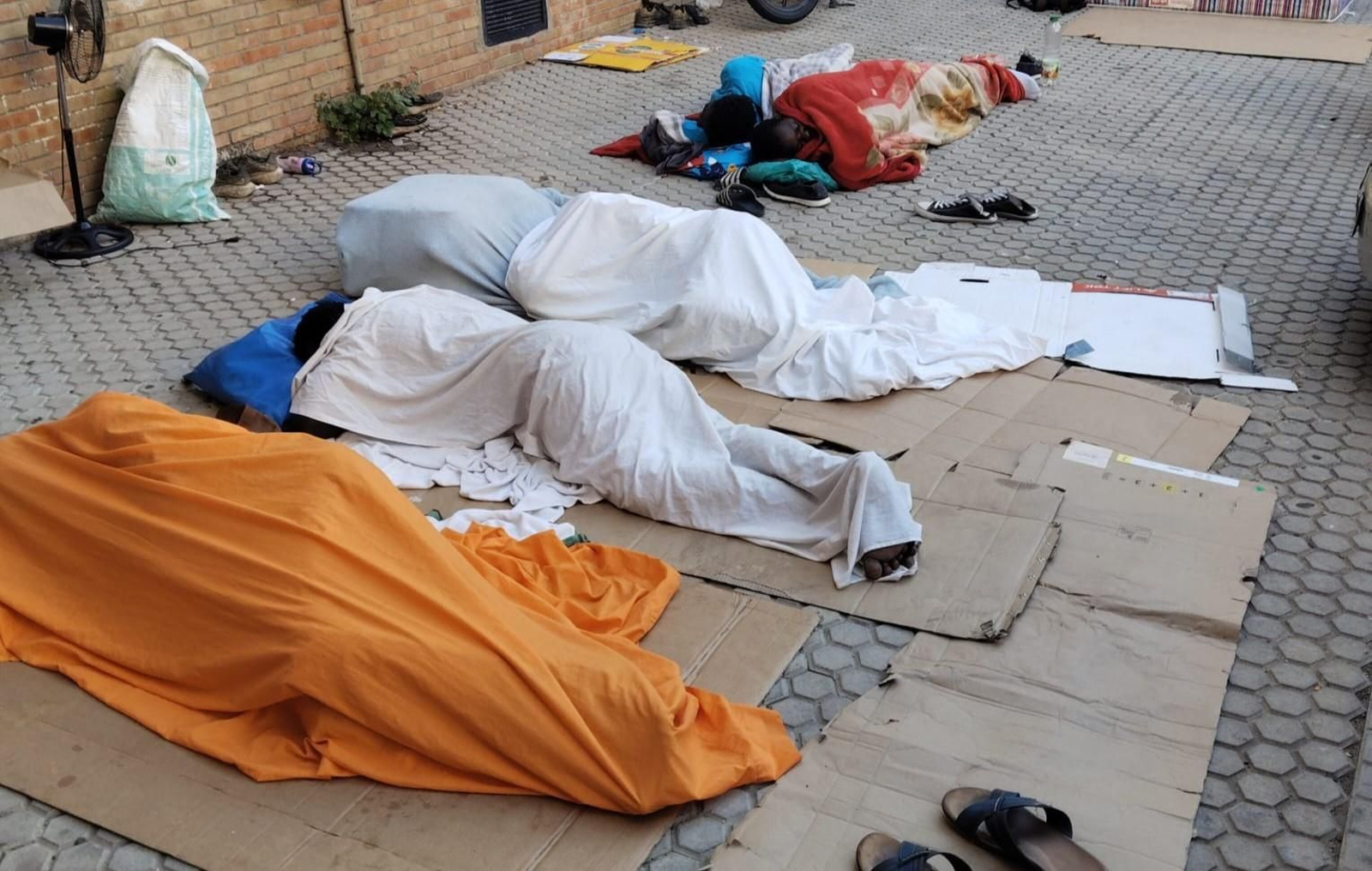 Personas sin hogar duermen en una calle del Distrito Macarena.