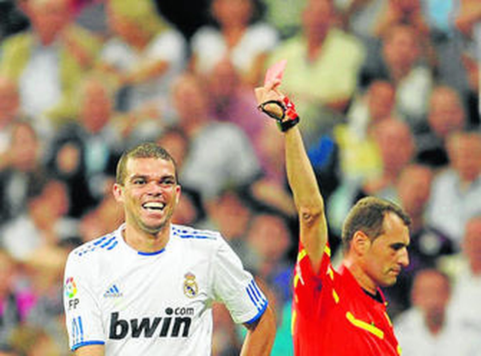 El árbitro, Clos Gómez, muestra la cartulina roja al portugués Pepe, que ríe de forma irónica.