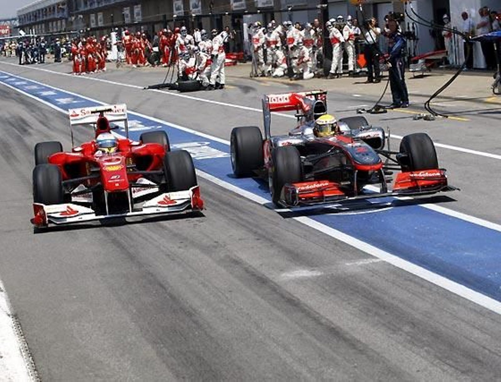 Lewis Hamilton (McLaren) lleva a cabo una maniobra antirreglamentaria en el 'pit lane' para salir de 'boxes' antes que Fernando Alonso (Ferrari). Pero Alonso consiguió salir antes que él.

Foto: Afp Photo / Reuters / Efe