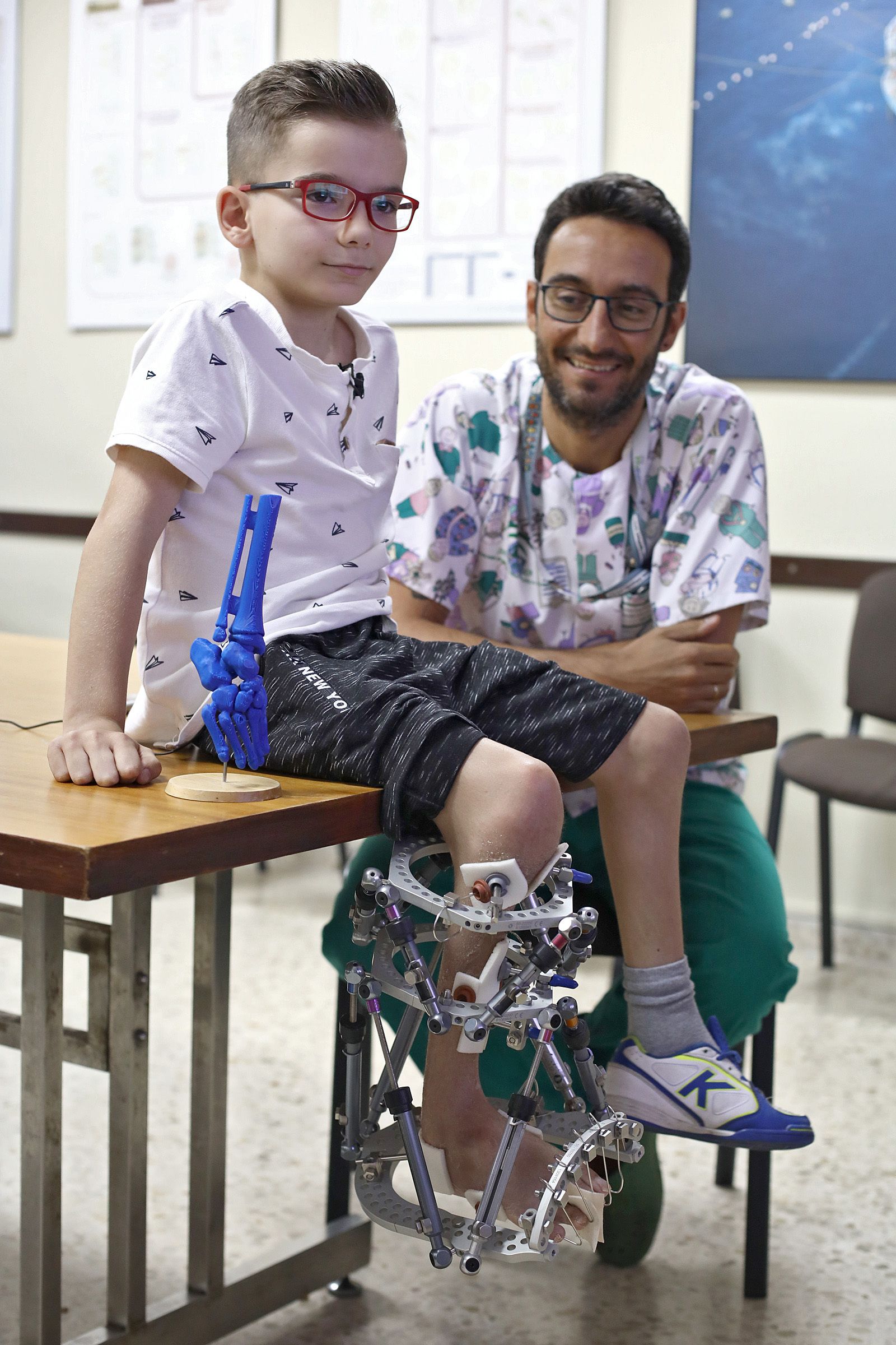 Gabriel con Juan José Domínguez junto a una reproducción en 3D de su pie.