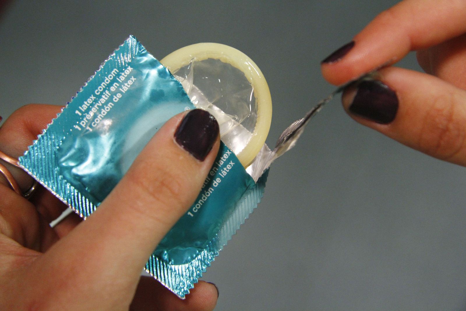 Una mujer abre un preservativo.