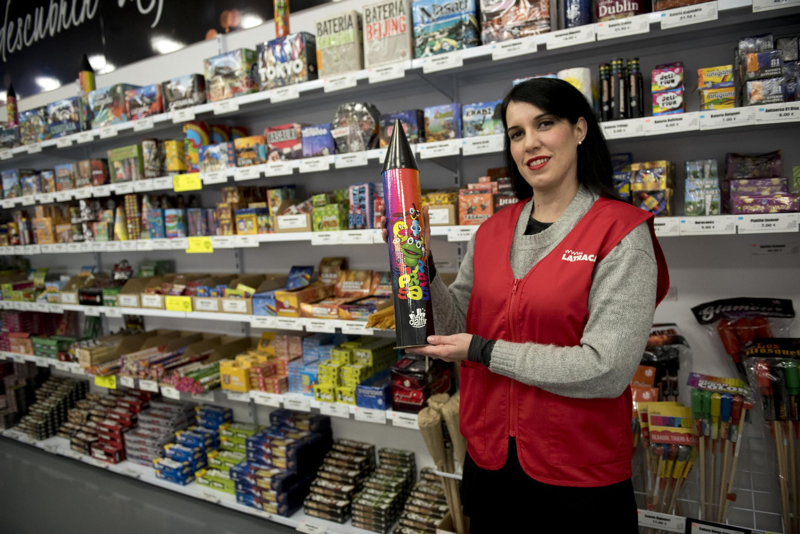 La dependienta de la tienda La Traca muestra uno de los cohetes más grandes de la tienda.