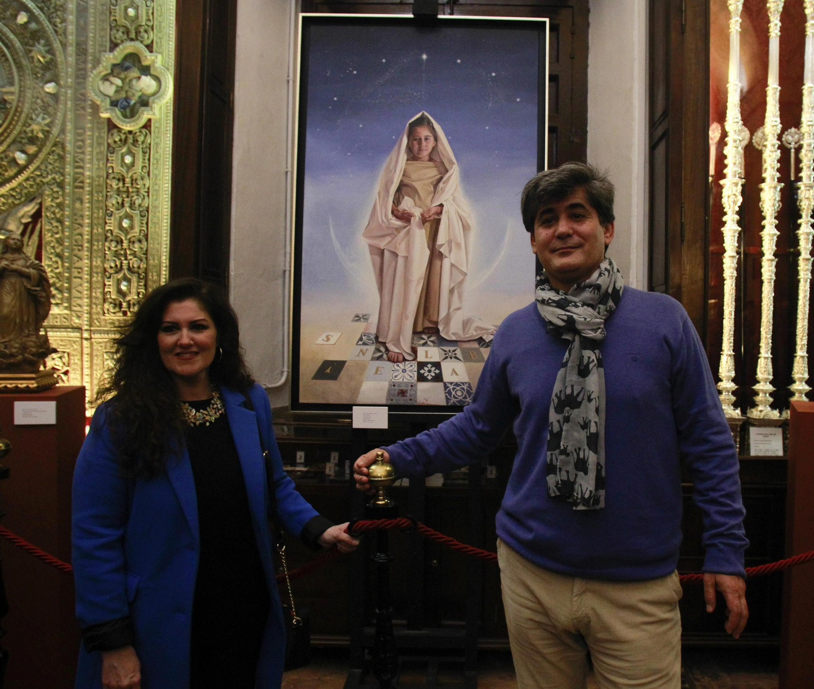 Elena Montero y el periodista José Luis Martínez posan junto al cuadro pintado por Montero.