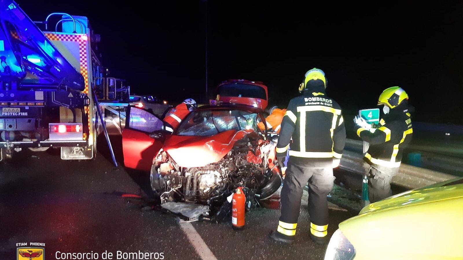 Los bomberos, con el otro coche del choque frontal de anoche.