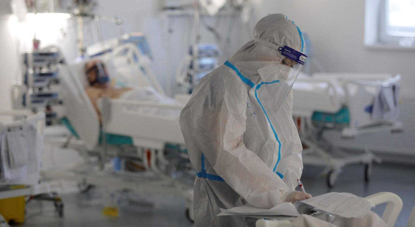 Una profesional sanitaria comprueba la hoja clínica de un paciente covid.