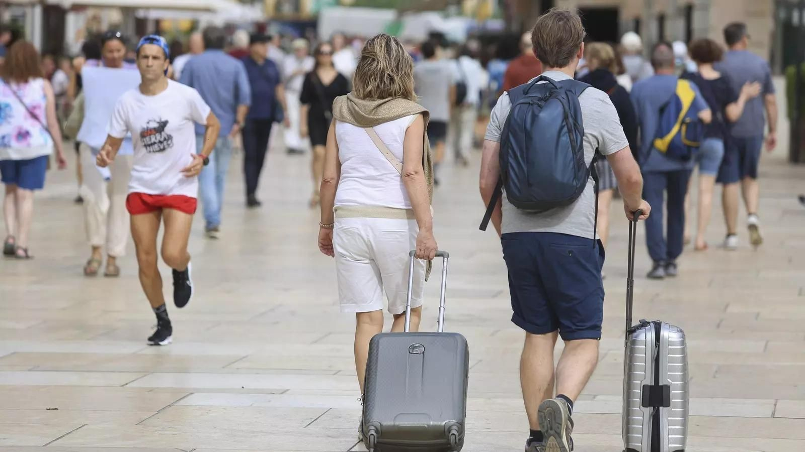 Turistas con maletas por las calles del centro de Málaga.